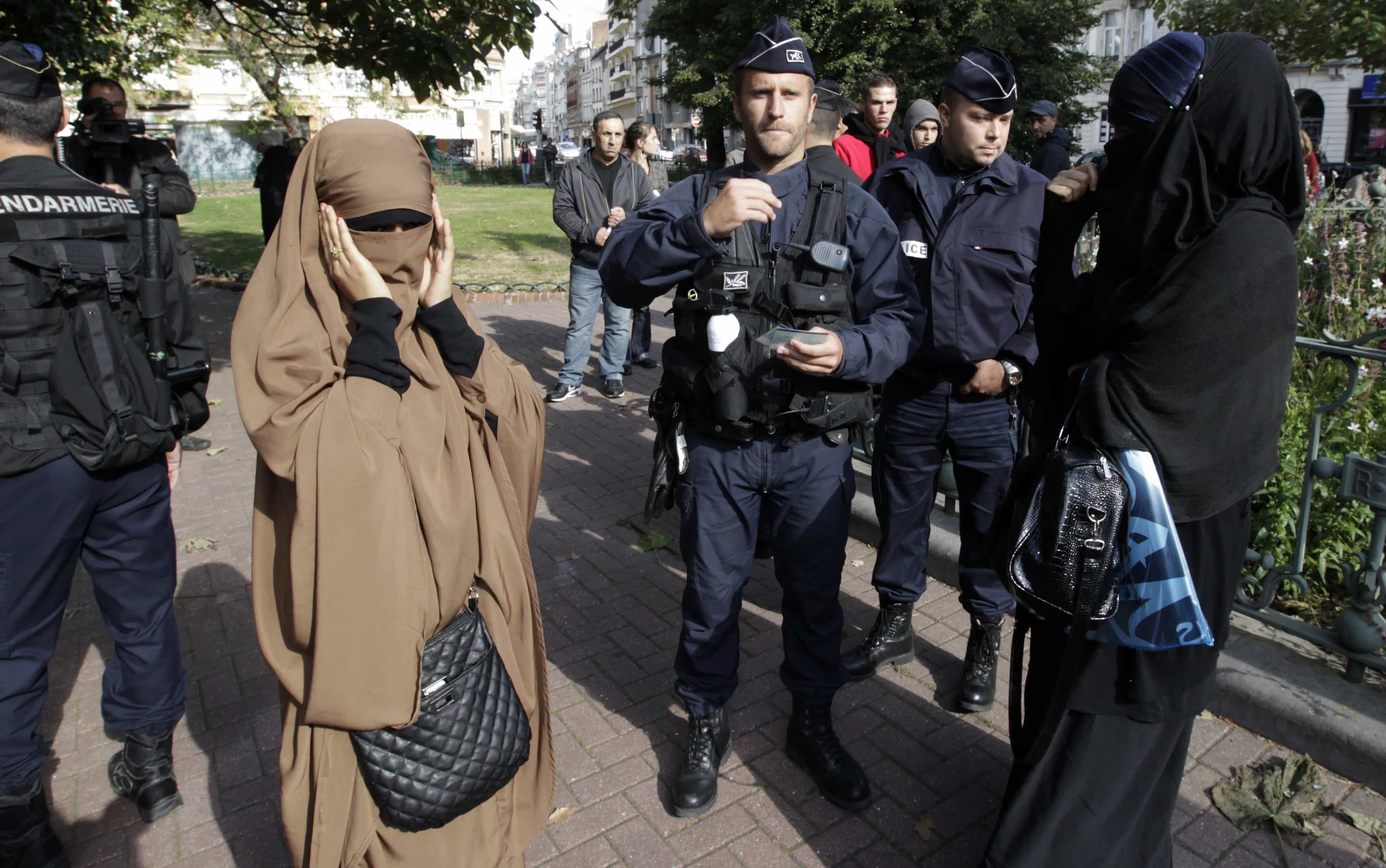 French police and gendarmes check identity cards of two women for wearing full-face veils, or niqabs, in Lille, 22 September 2012., REUTERS/Pascal Rossignol