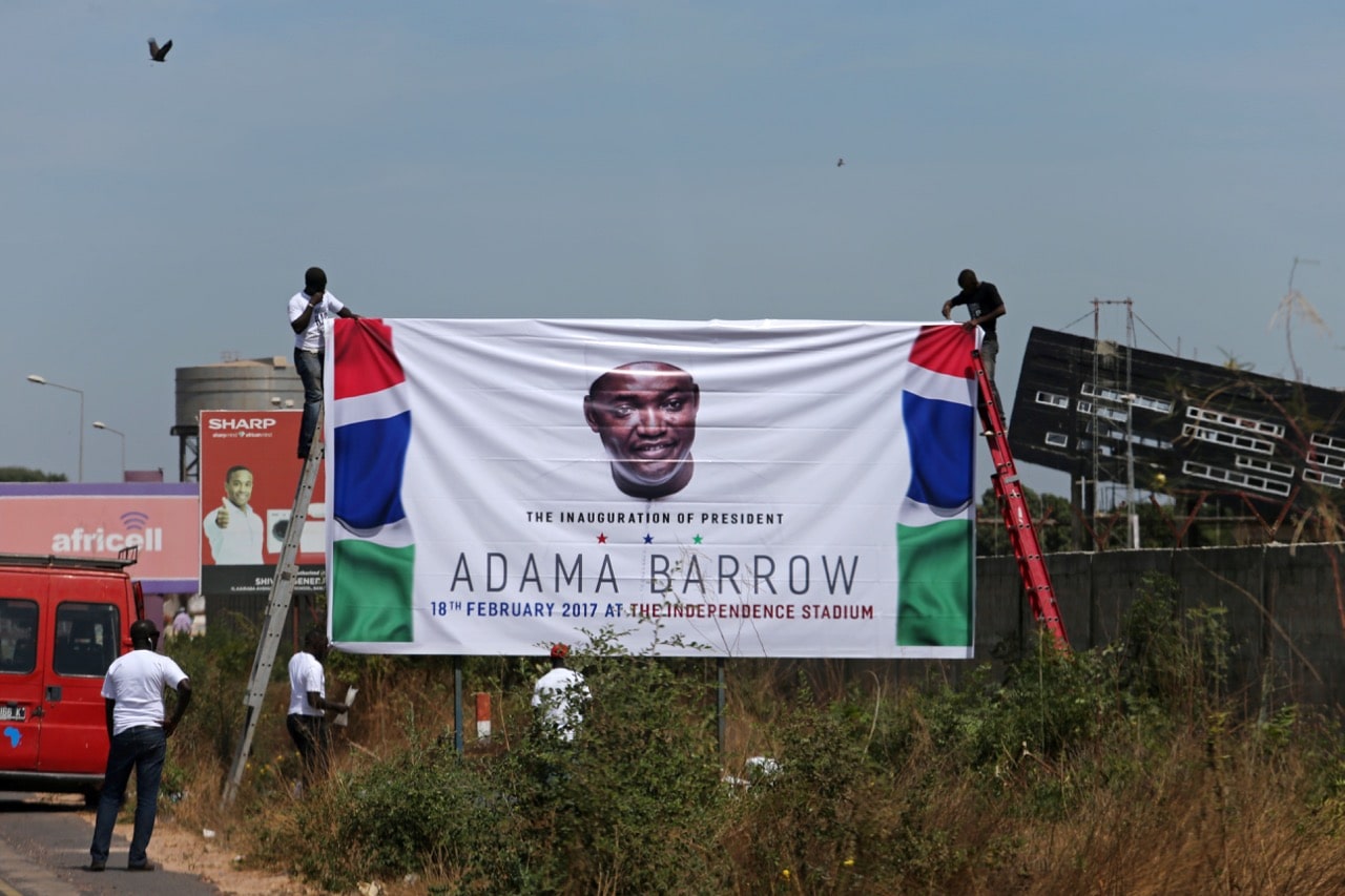 Supporters of Gambia's President Adama Barrow fix a billboard ahead of his slated return to Banjul, 26 January 2017, REUTERS/Afolabi Sotunde