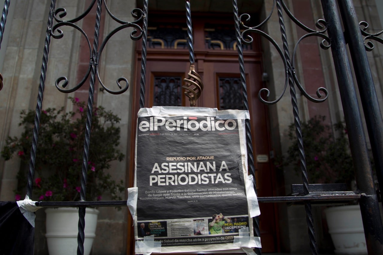 In this 11 March 2015 file photo, a copy of the front page of the newspaper "El Periodico de Guatemala", that reads in Spanish "Journalists killed", hangs on the main gate of the Presidential House during a protest, AP Photo/Moises Castillo, File