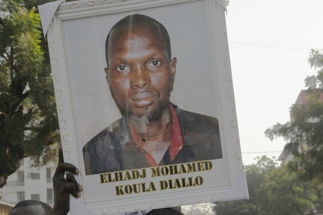 A protester holds a portrait of journalist El Hadj Mohamed Diallo, in Conakry, Guinea, 8 February 2016, CELLOU BINANI/AFP/Getty Images