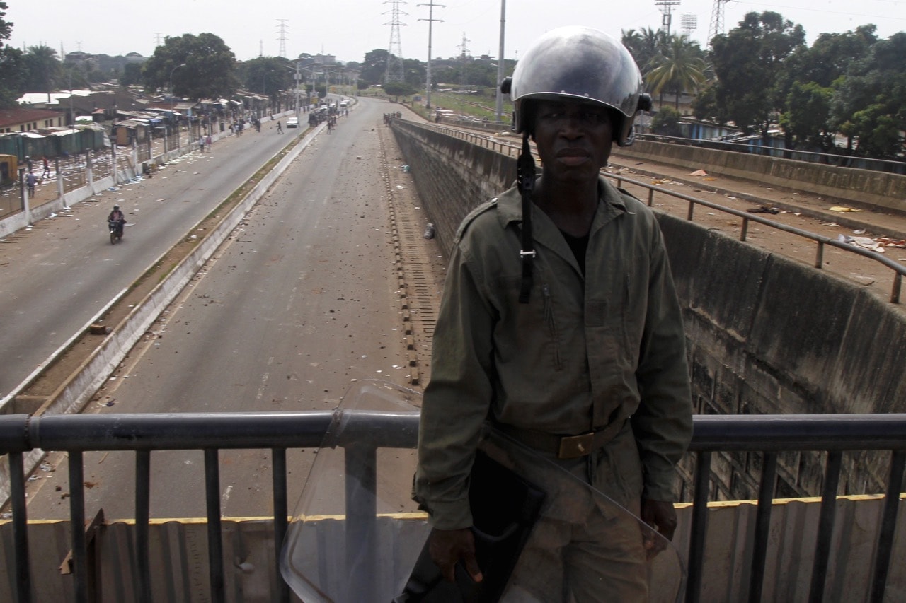 A Guinean soldier stands on a bridge next to a market where shops were burnt and looted after clashes between supporters of President Alpha Conde and his main election rival Cellou Dalein Diallo, in Conakry, Guinea, 9 October 2015, REUTERS/Luc Gnago