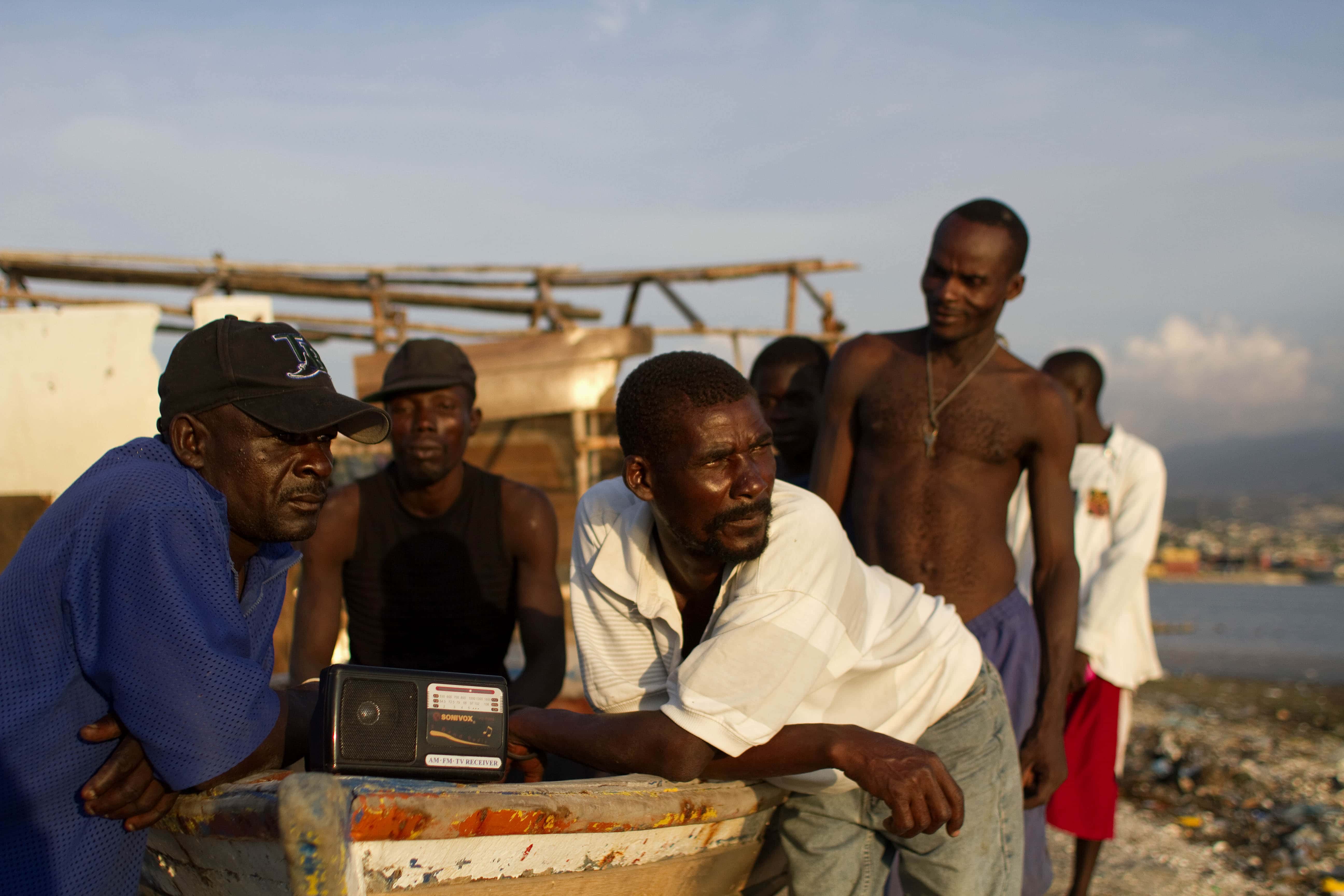 In this March 26, 2012 photo, fishermen listen to news on a radio as they rest in Port-au-Prince, Haiti., AP Photo/Dieu Nalio Chery