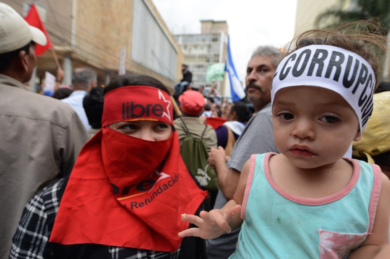 A child wears a headband reading 'Corruption' as opposition supporters call for the resignation of Honduran President Hernandez following allegations of corruption in Tegucigalpa, 3 June 2015, ORLANDO SIERRA/AFP/Getty Images