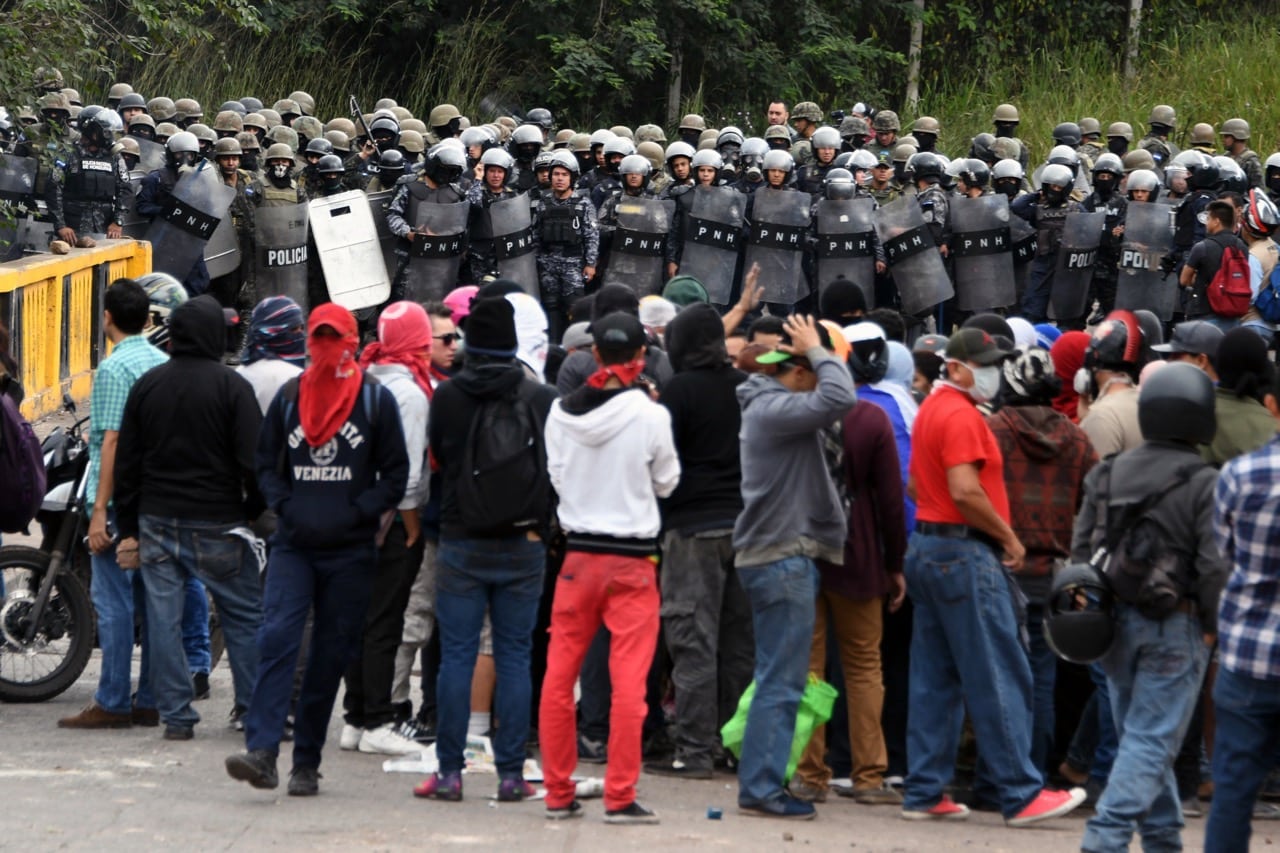 Partidarios del candidato presidencial Salvador Nasralla enfrentan miembros de la Policía antimotines, durante una protesta contra la reelección del Presidente Juan Orlando Hernández, en Tegucigalpa, Honduras, el 22 de diciembre de 2017, ORLANDO SIERRA/AFP/Getty Images