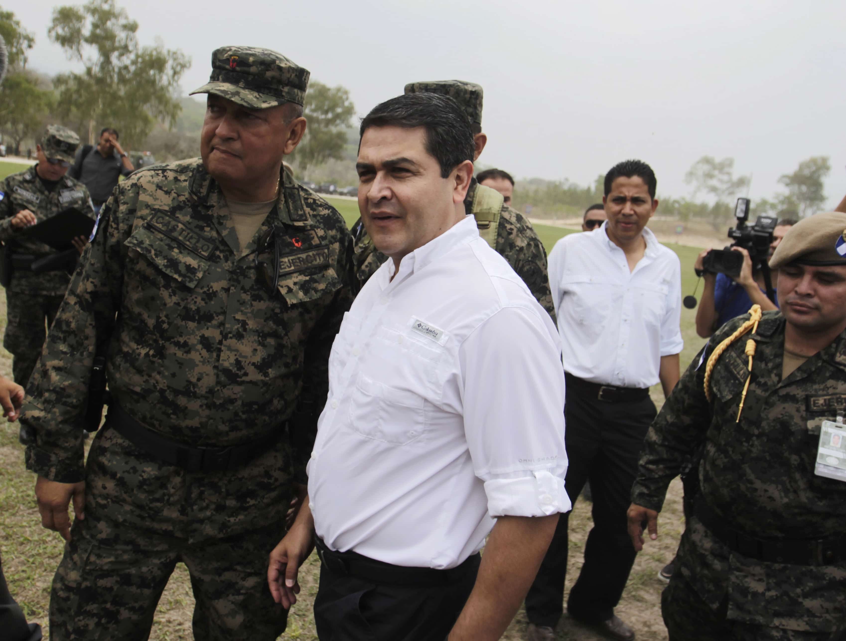 Honduras' President Juan Orlando Hernandez talks to officers of Honduras' army during a presentation in Mateo, on the outskirts of Tegucigalpa May 7, 2014, REUTERS/Jorge Cabrera