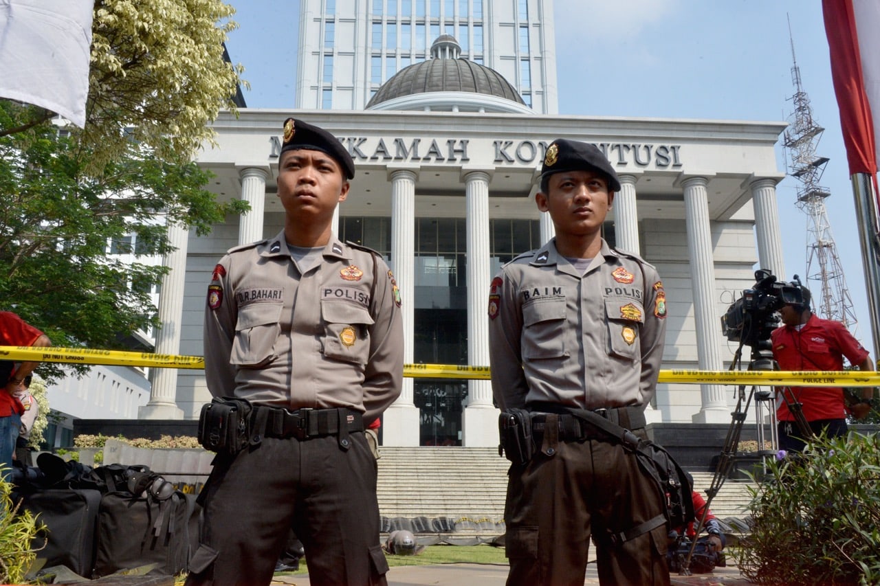 Police officers stand guard in front of Indonesia's Constitutional Court during a protest in Jakarta, 8 August 2014, BAY ISMOYO/AFP/Getty Images