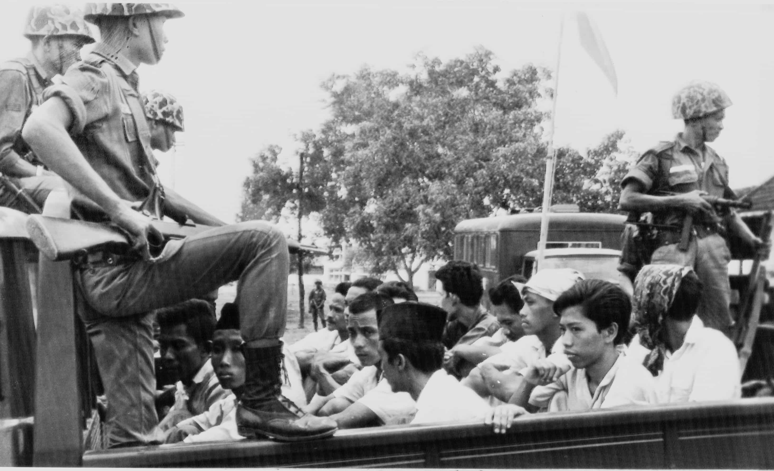 In this 30 October 1965 file photo, members of the Youth Wing of the Indonesian Communist Party are guarded by soldiers as they are being taken to prison in Jakarta, AP Photo/File