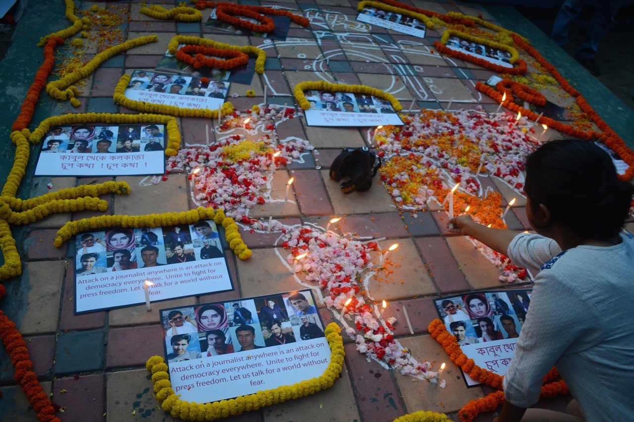 A world map decorated with flowers pays tribute to media personnel killed in Kabul, Afghanistan and elsewhere, during an event in Kolkata, West Bengal, India, 2 May 2018, Saikat Paul/Pacific Press/LightRocket via Getty Images