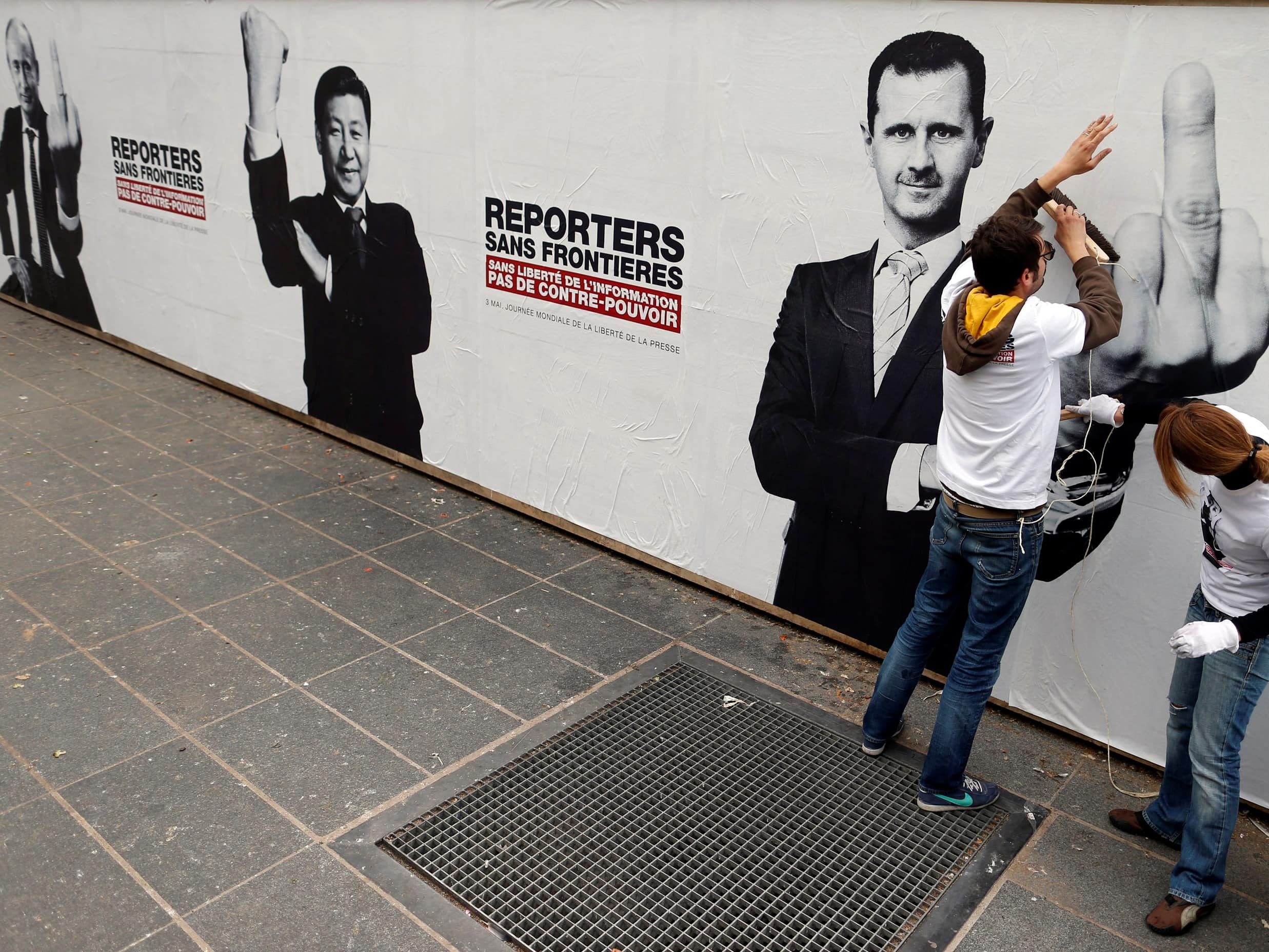 RSF activists paste a poster depicting Russia's President Vladimir Putin (L) and his counterparts from China, Xi Jinping (C) and Syria, Bashar al-Assad, in Paris 3 May 2013, REUTERS/Benoit Tessier