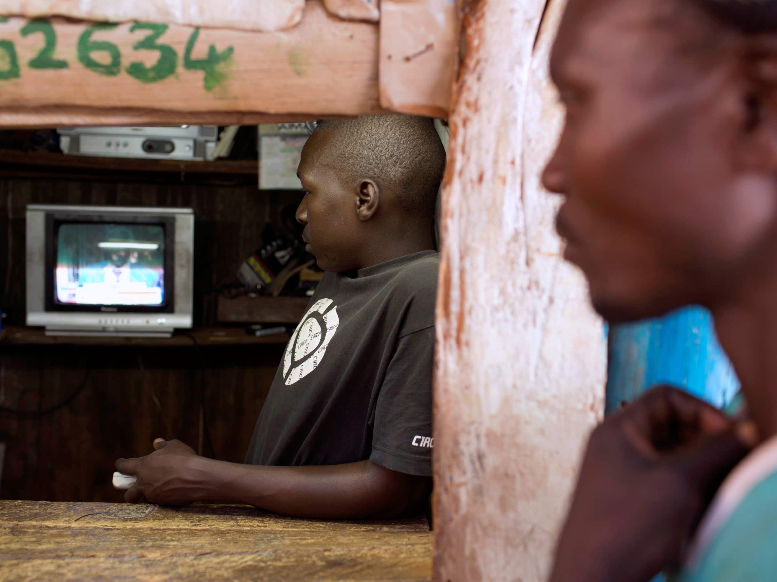 Men in a video store follow the latest electoral results in Nairobi, Kenya, March 2013, REUTERS/Siegfried Modola