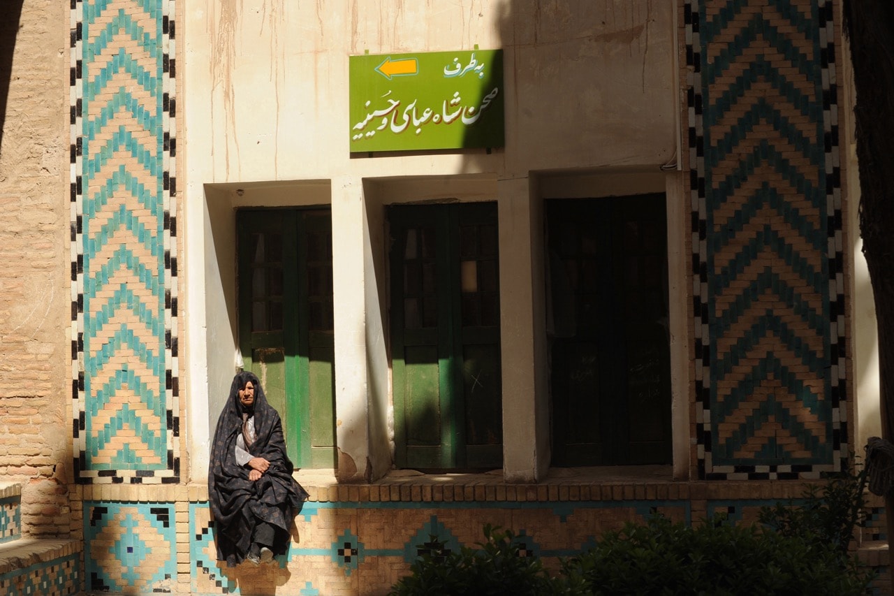 A woman in chador sits outside the tomb of a great Sufi leader in Mahan, Iran, 26 March 2011, Kaveh Kazemi/Getty Images