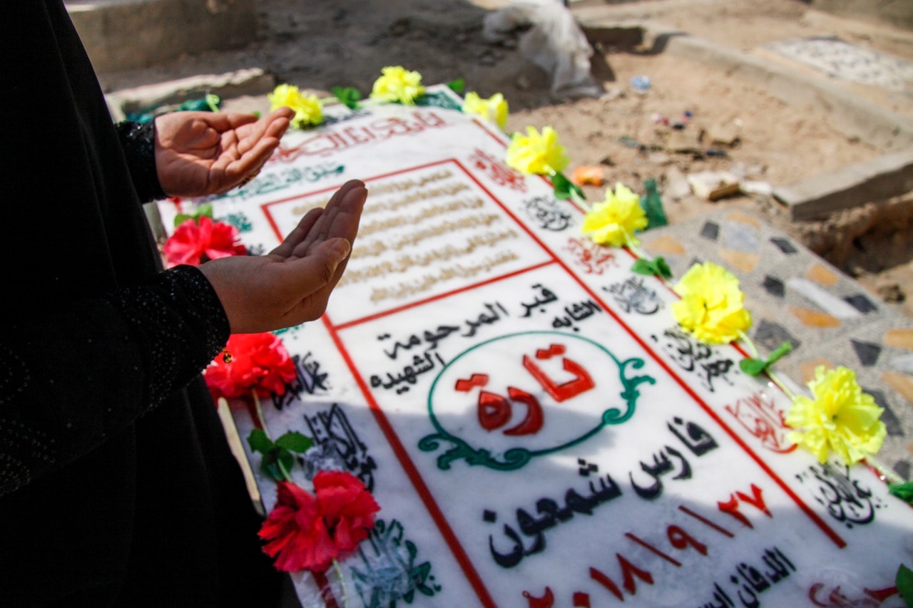 An Iraqi woman recites a prayer by the grave of slain model and Instagram starlet Tara Fares in the central holy shrine city of Najaf, 2 October 2018, HAIDAR HAMDANI/AFP/Getty Images