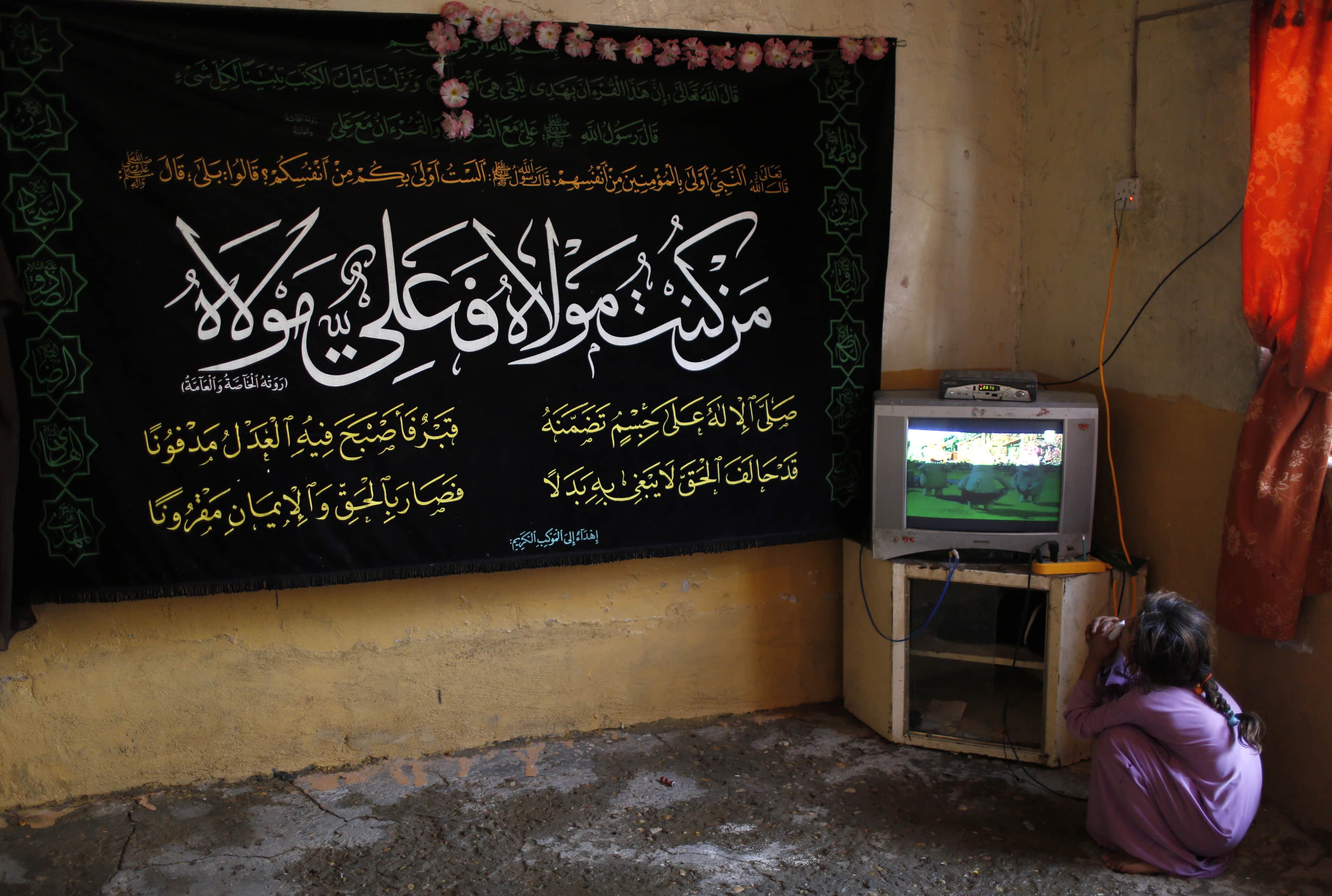 An Iraqi girl watches television inside her house in Baghdad, 3 May 2014, REUTERS/Ahmed Jadallah