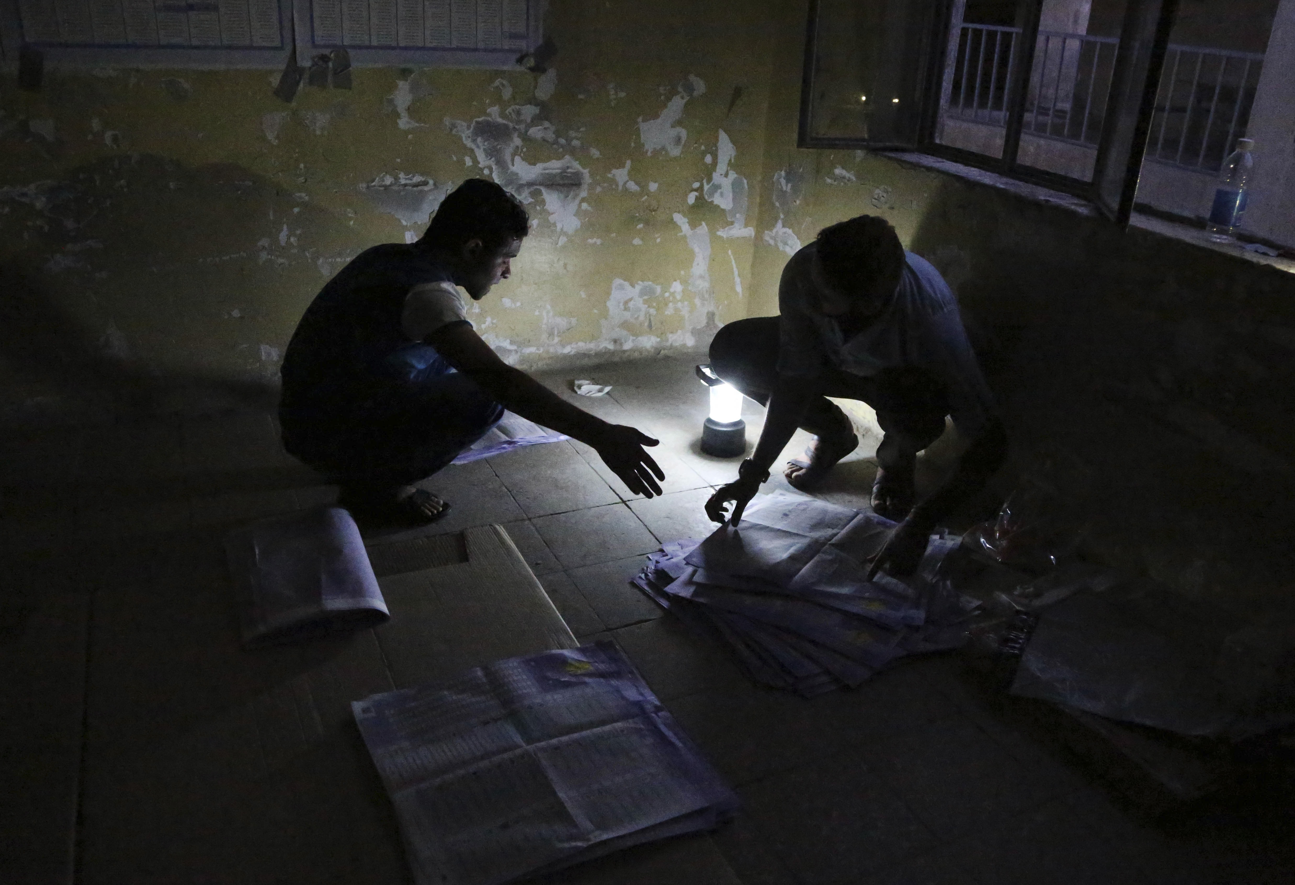 Electoral workers count ballots under lamplight, due to a power cut, as polls close at a polling center in Baghdad, Iraq on 30 April 2014, AP Photo/Karim Kadim