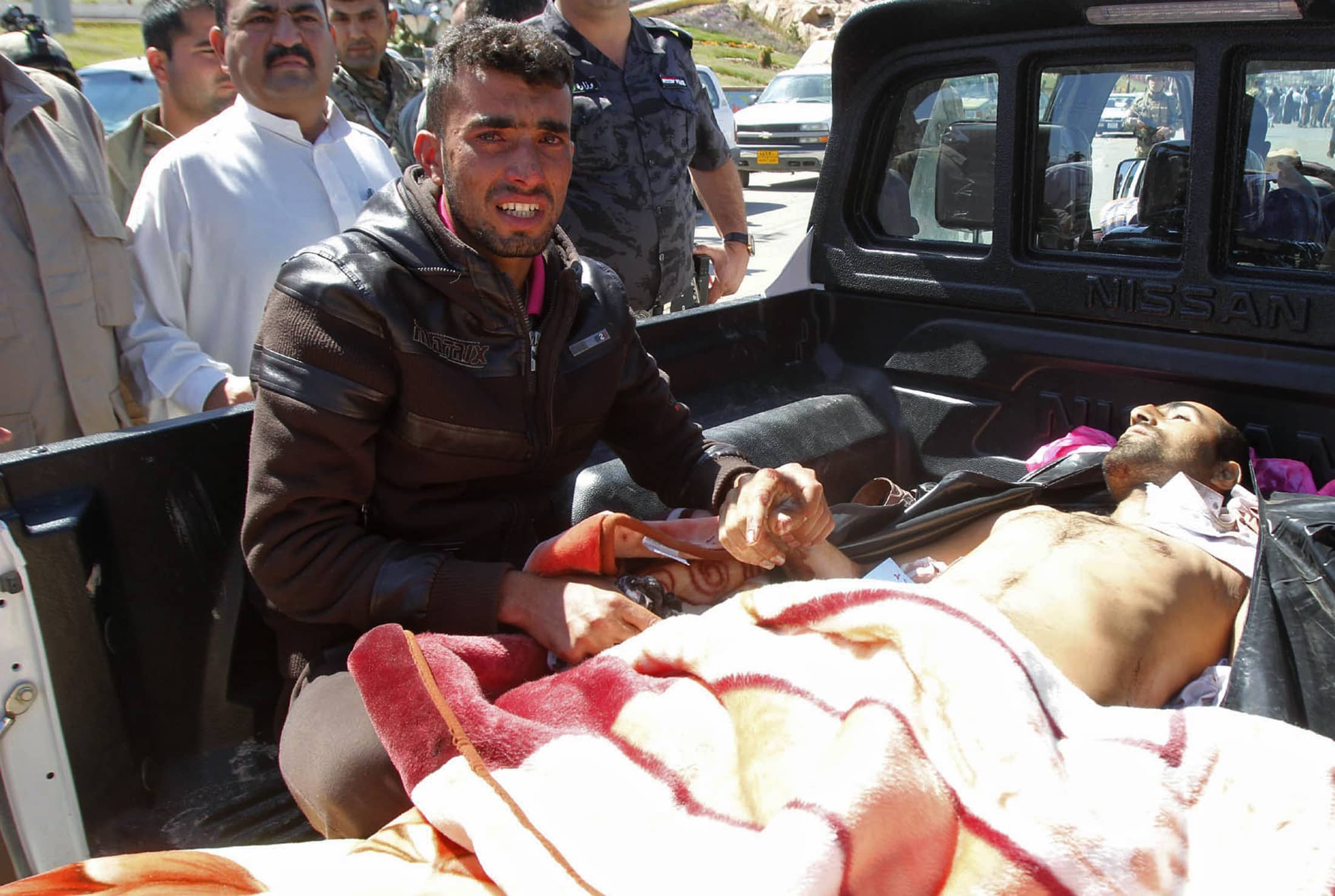 A man cries next to the body of his brother during a funeral on 24 April 2013 for protesters who died during a clash between Iraqi forces and Sunni Muslim protesters north of Baghdad, REUTERS/Ako Rasheed