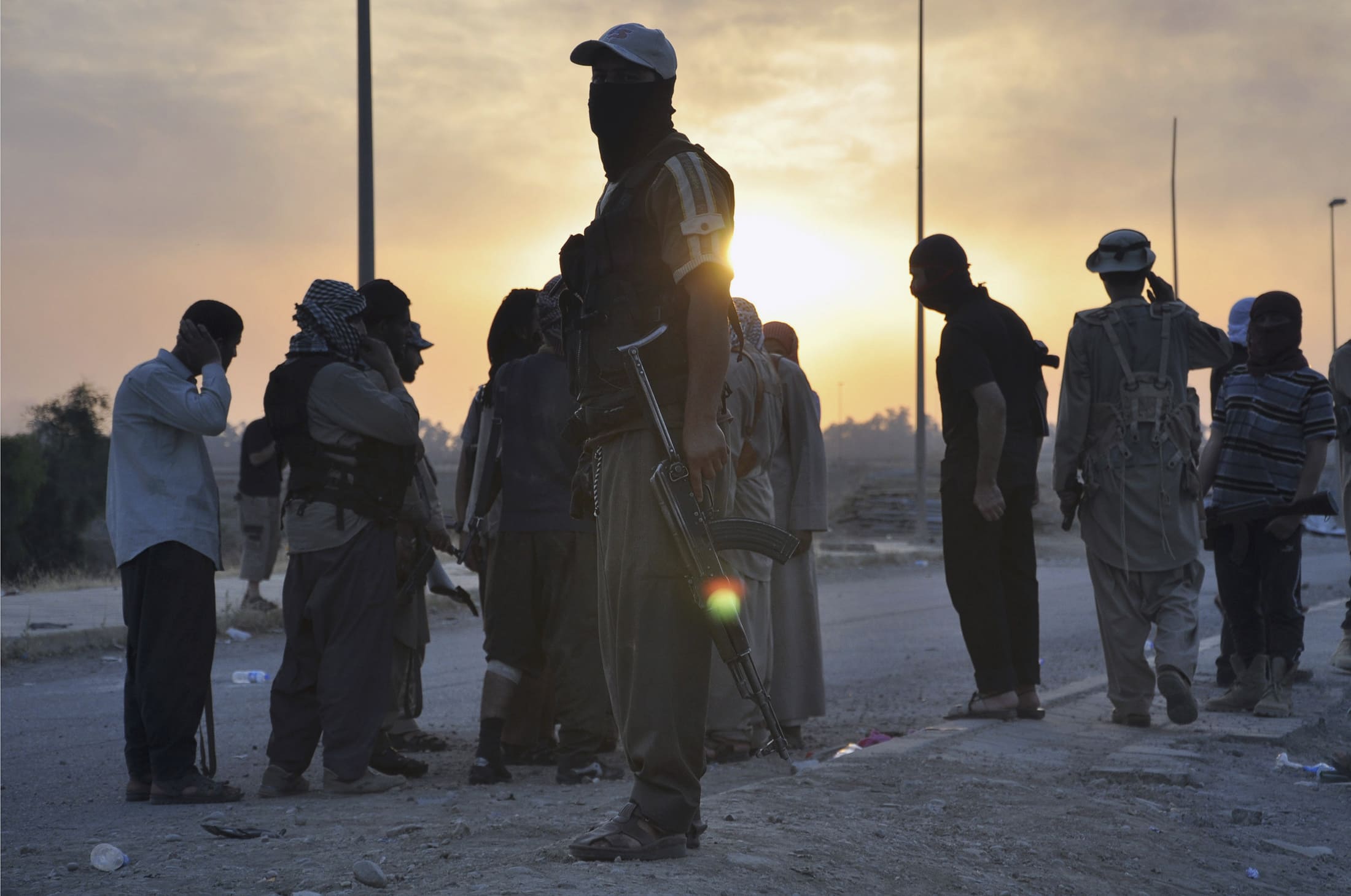 Fighters of the Islamic State stand guard at a checkpoint in the northern Iraq city of Mosul on 11 June 2014, REUTERS/Stringer