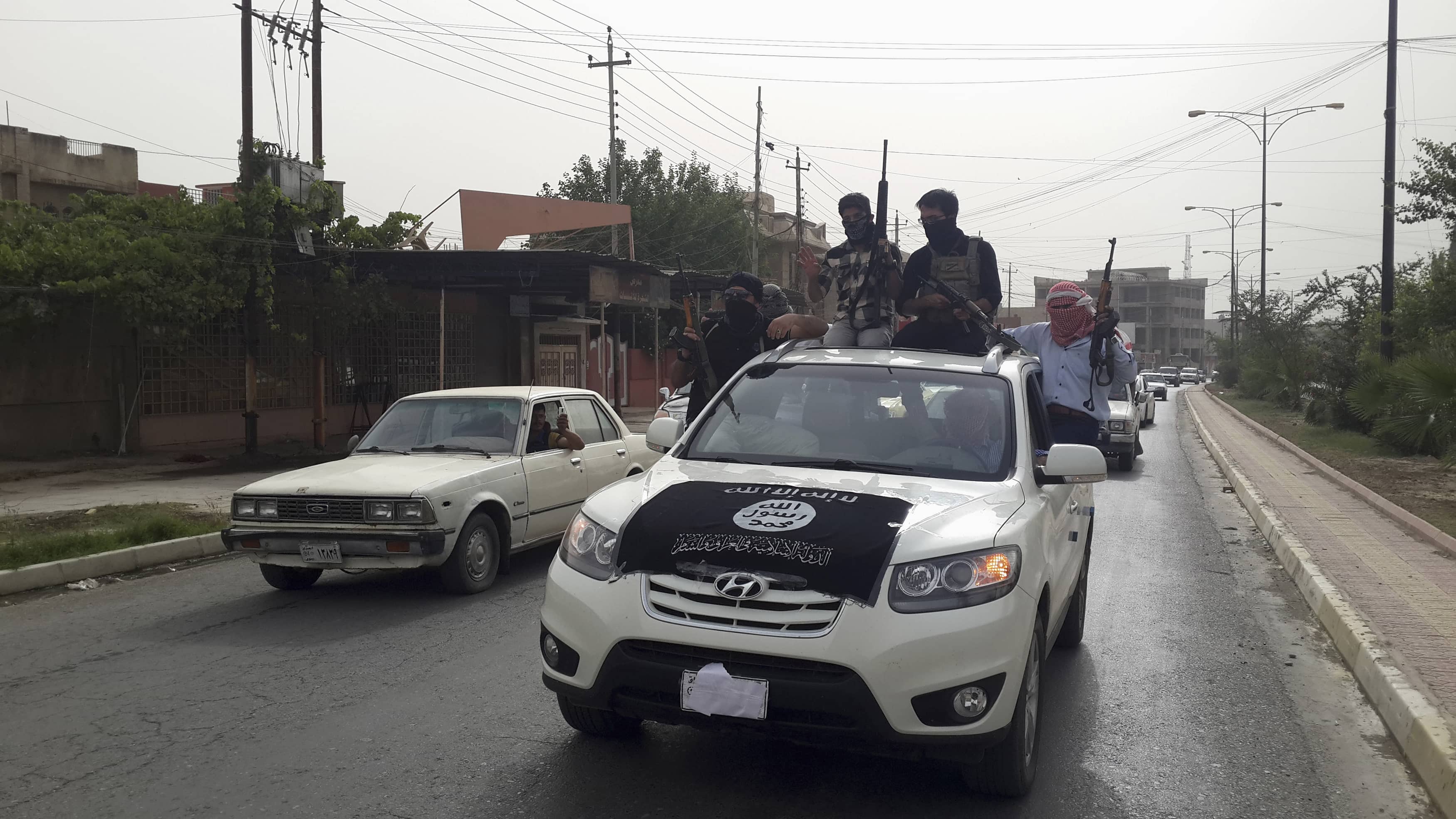 Fighters of the Islamic State of Iraq and the Levant (ISIL) celebrate on vehicles taken from Iraqi security forces, at a street in city of Mosul, June 12, 2014, REUTERS/Stringer