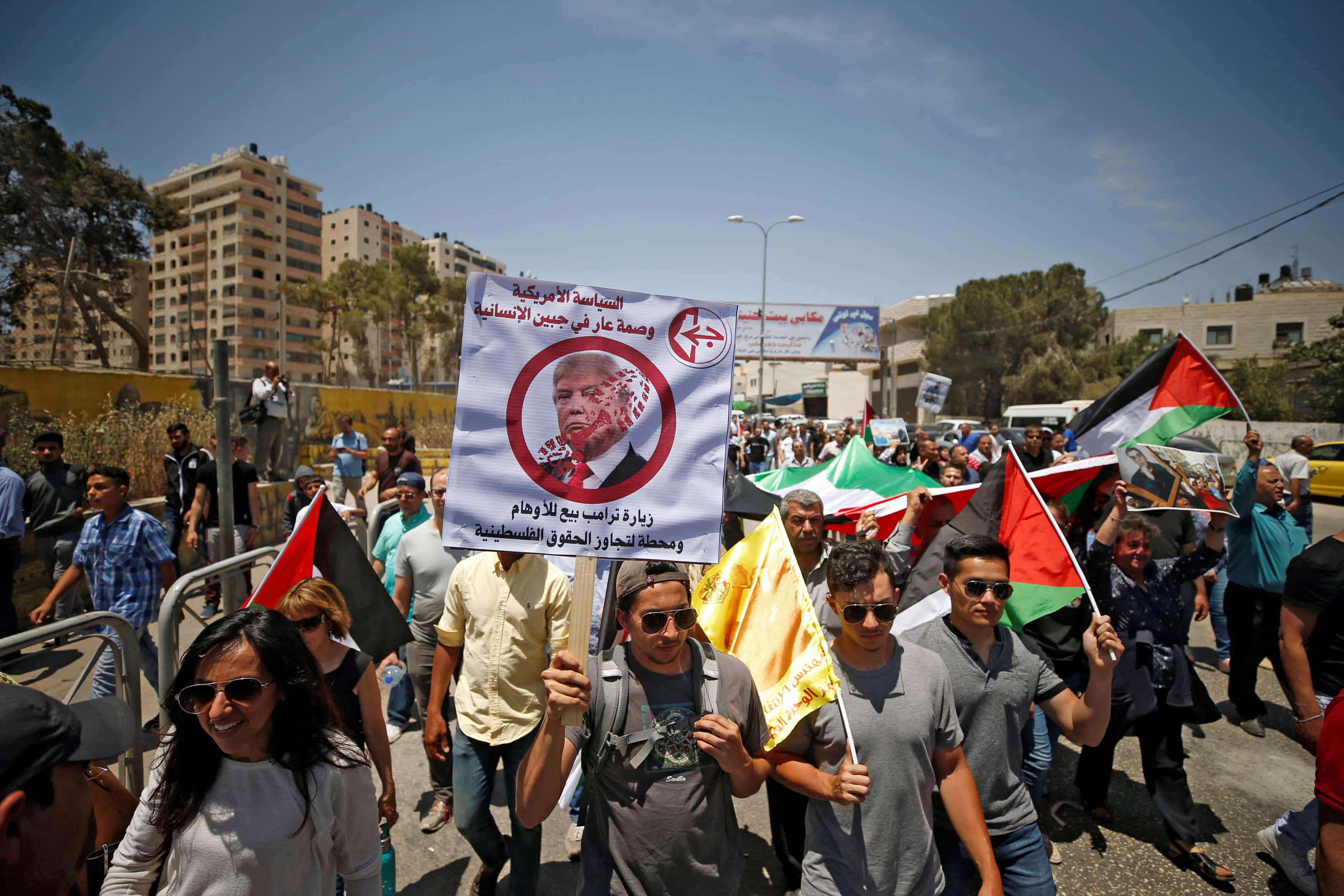 A Palestinian demonstrator holds an anti-Donald Trump poster during a protest in support of Palestinian prisoners on hunger strike in Israeli jails, near the West Bank city of Ramallah, 22 May 2017, REUTERS/Mohamad Torokman