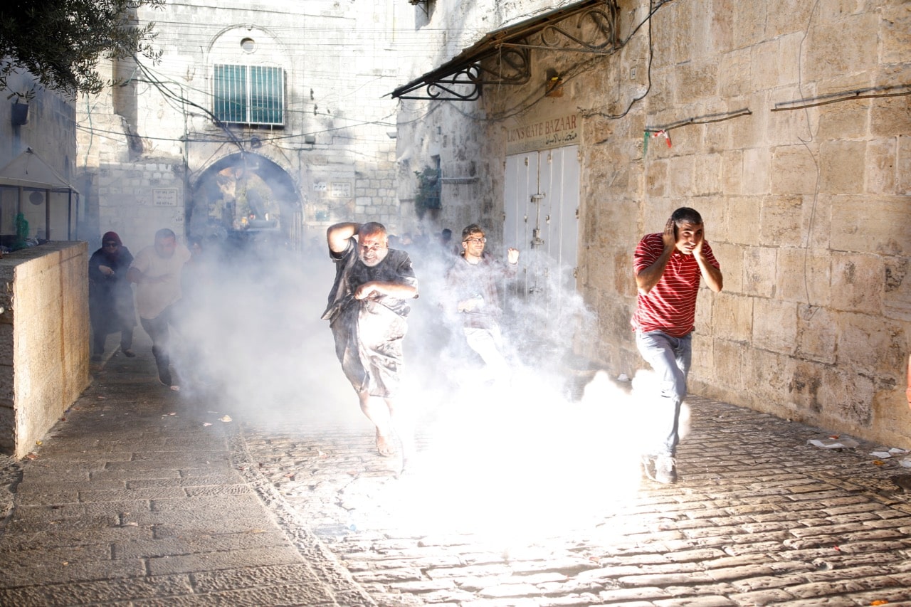Palestinians react as a stun grenade explodes in a street at Jerusalem's Old city outside a compound known to Muslims as Noble Sanctuary and to Jews as Temple Mount, 27 July 2017, REUTERS/Amir Cohen