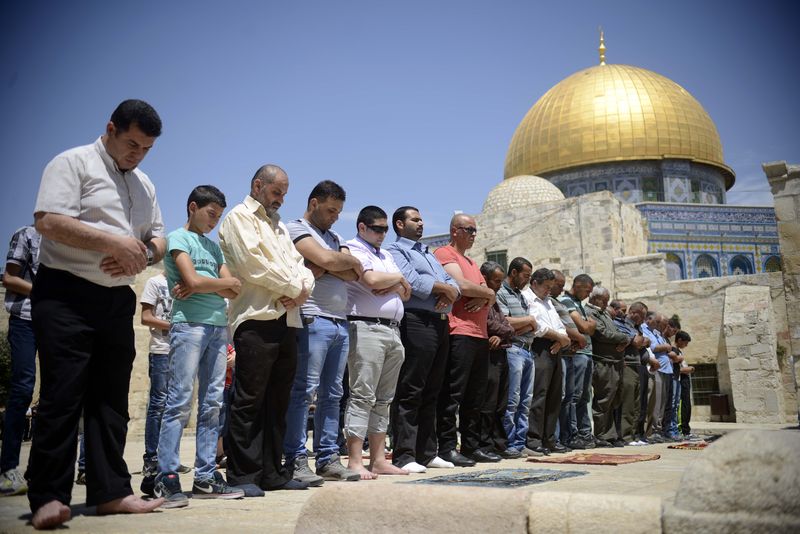 Palestinian muslim worshipers take part in Friday prayers outside the Dome of the Rock at the Al-Aqsa mosque compound in the Old City of Jerusalem on 25 April 2014, Demotix/Submitted by Mahmoud illean