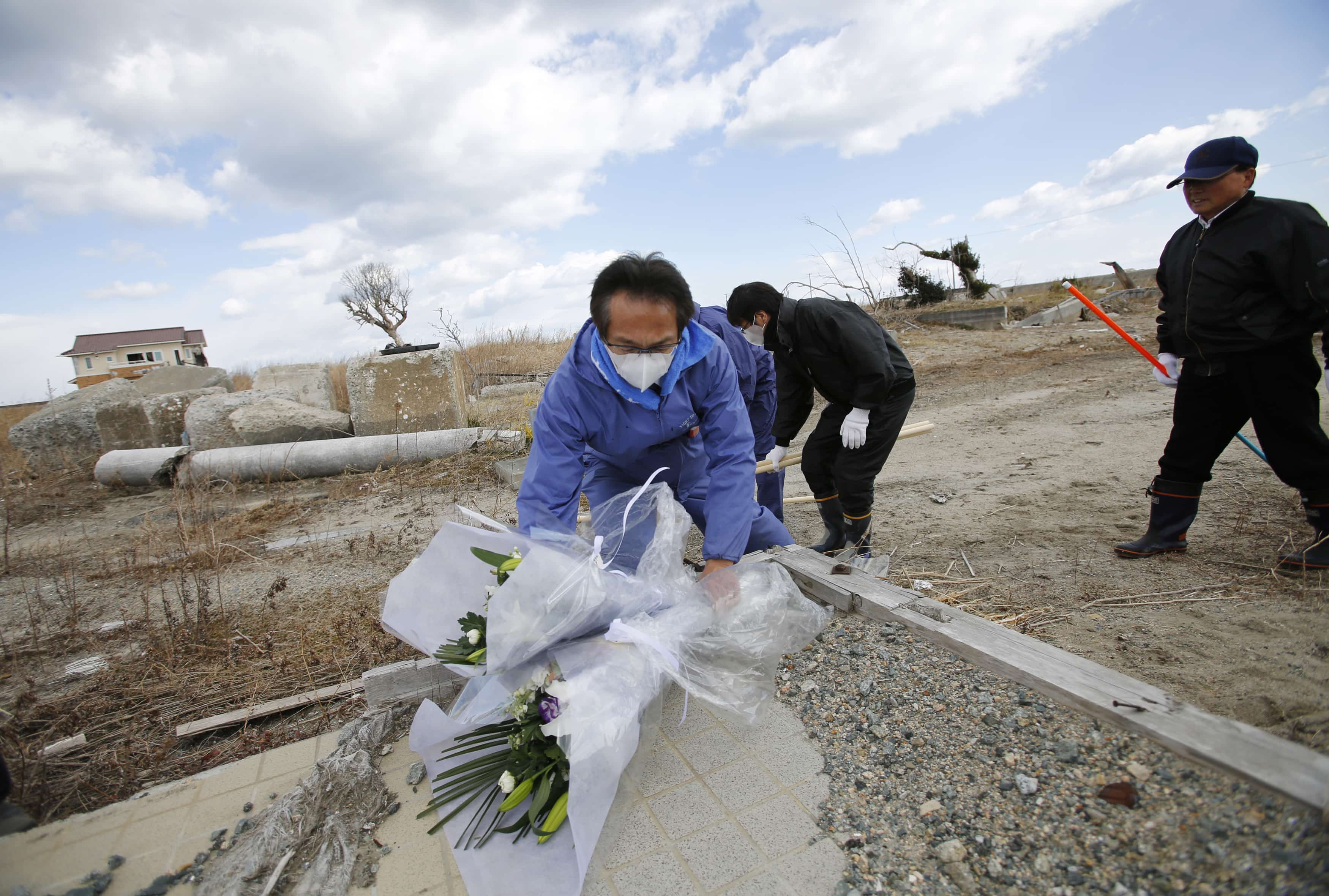 A man places flowers as he prays for victims of the 2011 earthquake and tsunami in Namie town, Fukushima prefecture, 11 March 2014, REUTERS/Toru Hanai