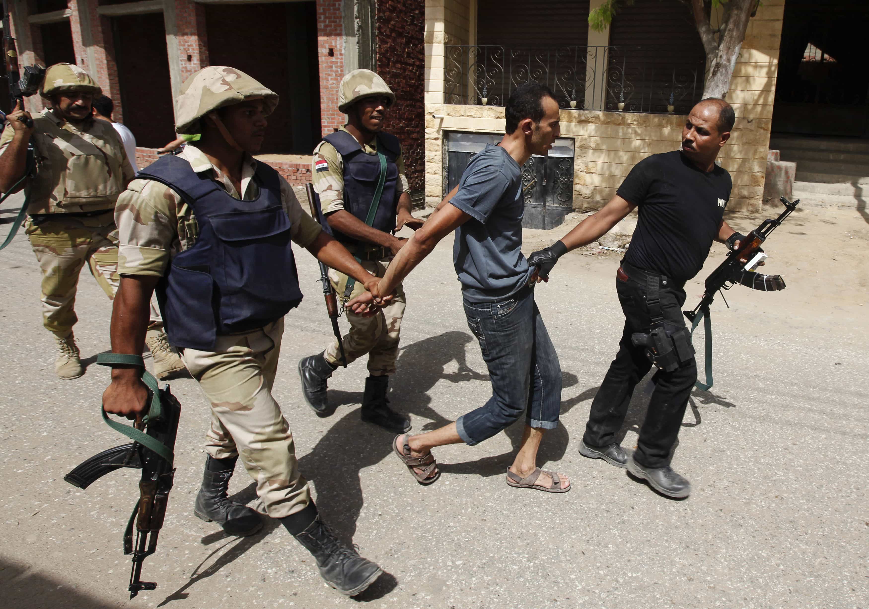 Security forces detain a suspect in Kerdasah in this 2013 file photo. An Egyptian court has sentenced 188 people over an attack on a police station near Cairo last year in which 12 policemen were killed, REUTERS/Mohamed Abd El Ghany