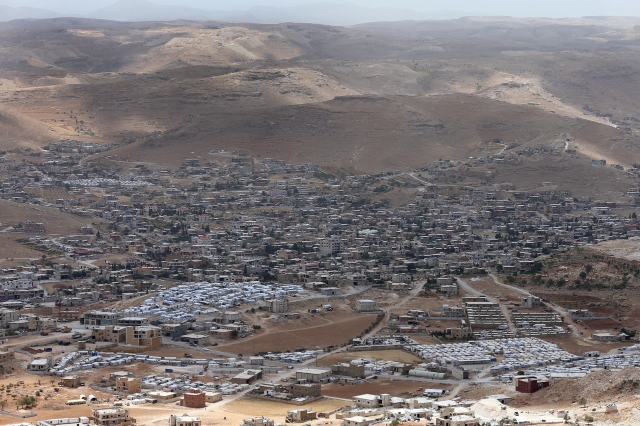 A 19 June 2016 photo shows several Syrian refugee camps in the foreground, and the town of Arsal, near the Syrian border, in northeast Lebanon, AP Photo/Hussein Malla