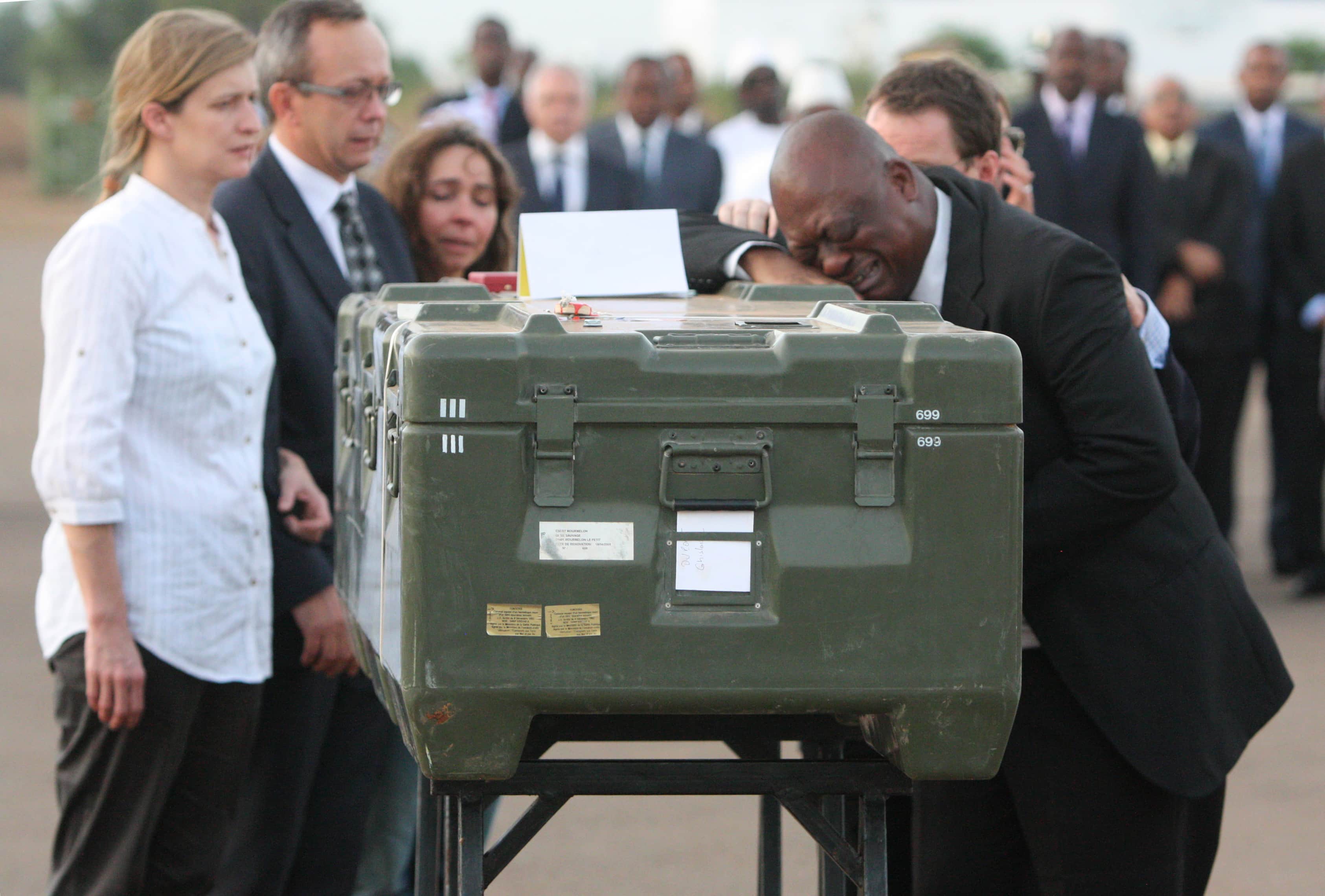 Serge Daniel, right, correspondent for Radio France Internationale, weeps at the coffin of one of the two French journalists executed in Mali, 4 November 2013., AP Photo/Harouna Traore