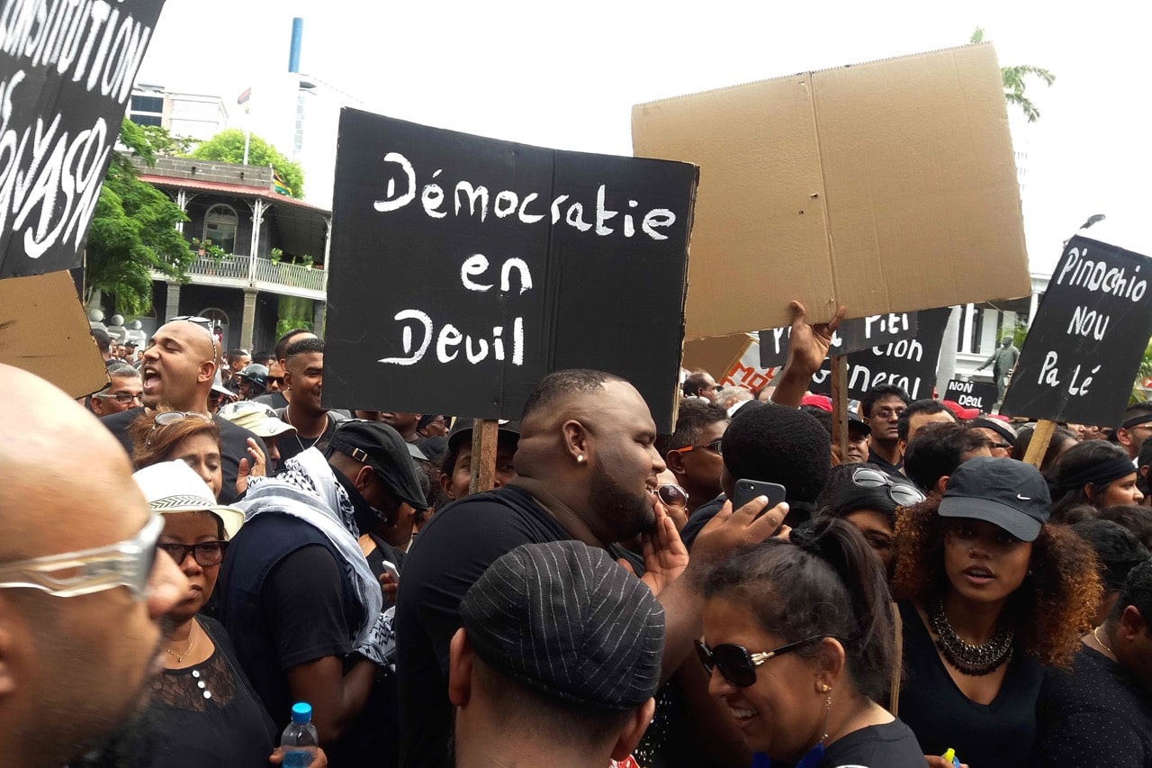 Protesters hold a placard reading 'Democracy in grief' during a demonstration in Port Louis, Mauritius on 27 January 2017, after former Prime Minister Sir Anerood Jugnauth handed over power to his son Pravind, JEAN MARC POCHE/AFP/Getty Images