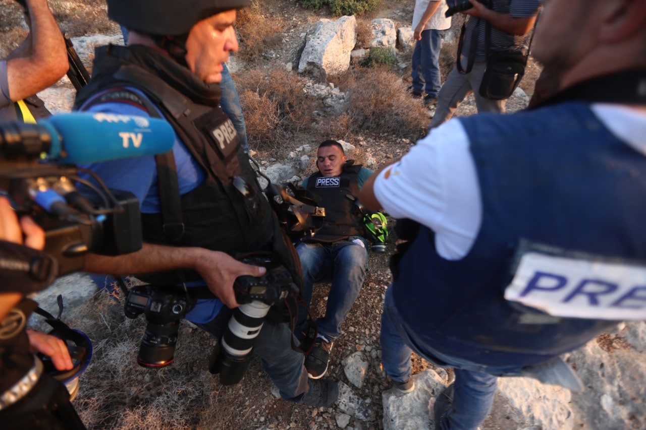 A photojournalist for Turkey's Anadolu Agency lies on the ground after being shot with rubber bullets by the Israeli forces while covering demonstrations in the village of Ras Karkar near Ramallah, West Bank, 4 September 2018, Shadi Hatem/Anadolu Agency/Getty Images