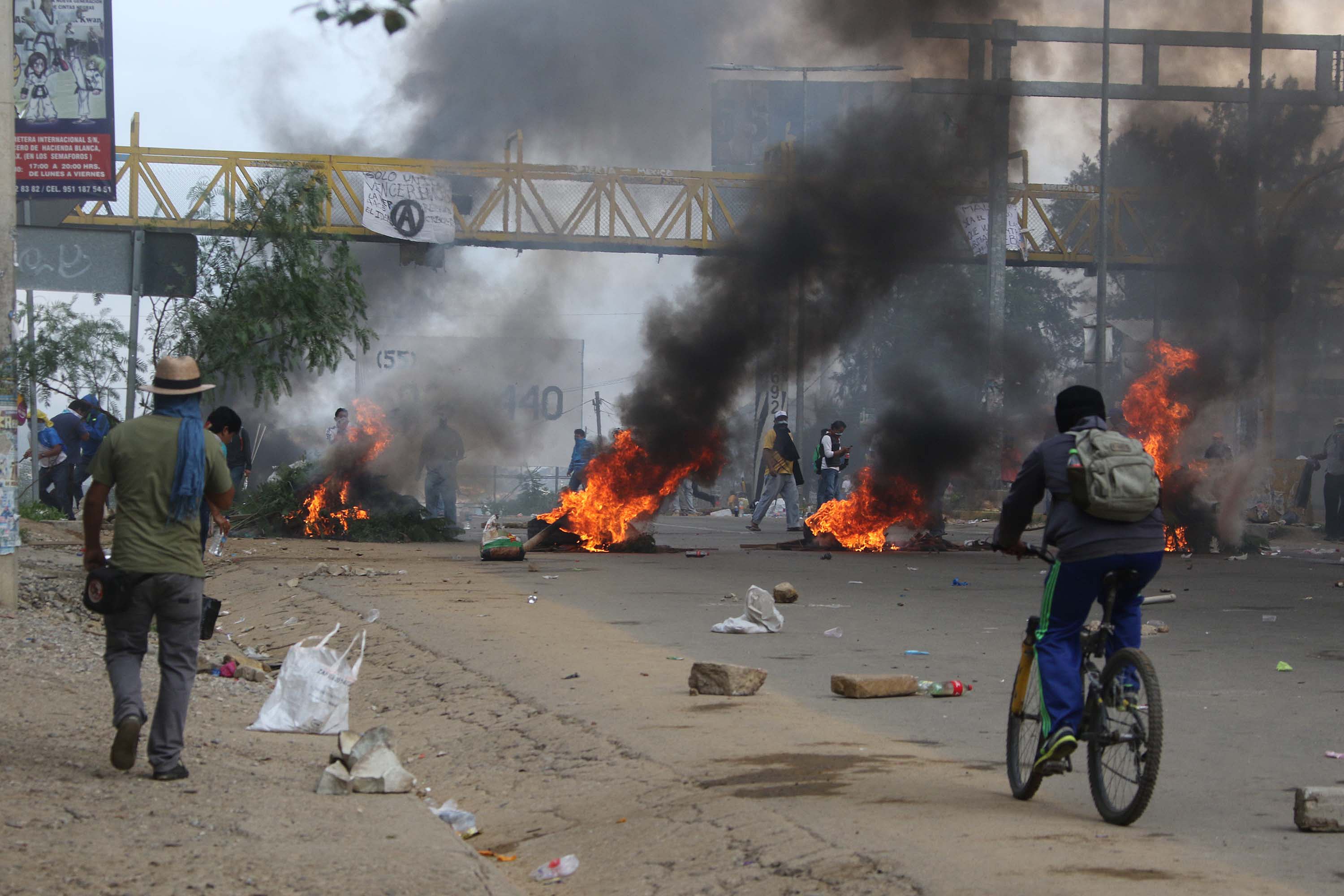 Protesting teachers hold their positions with burning tires as they battle all day with riot police in the state of Oaxaca, near the town of Nochixtlan, AP Photo/Luis Alberto Cruz Hernandez