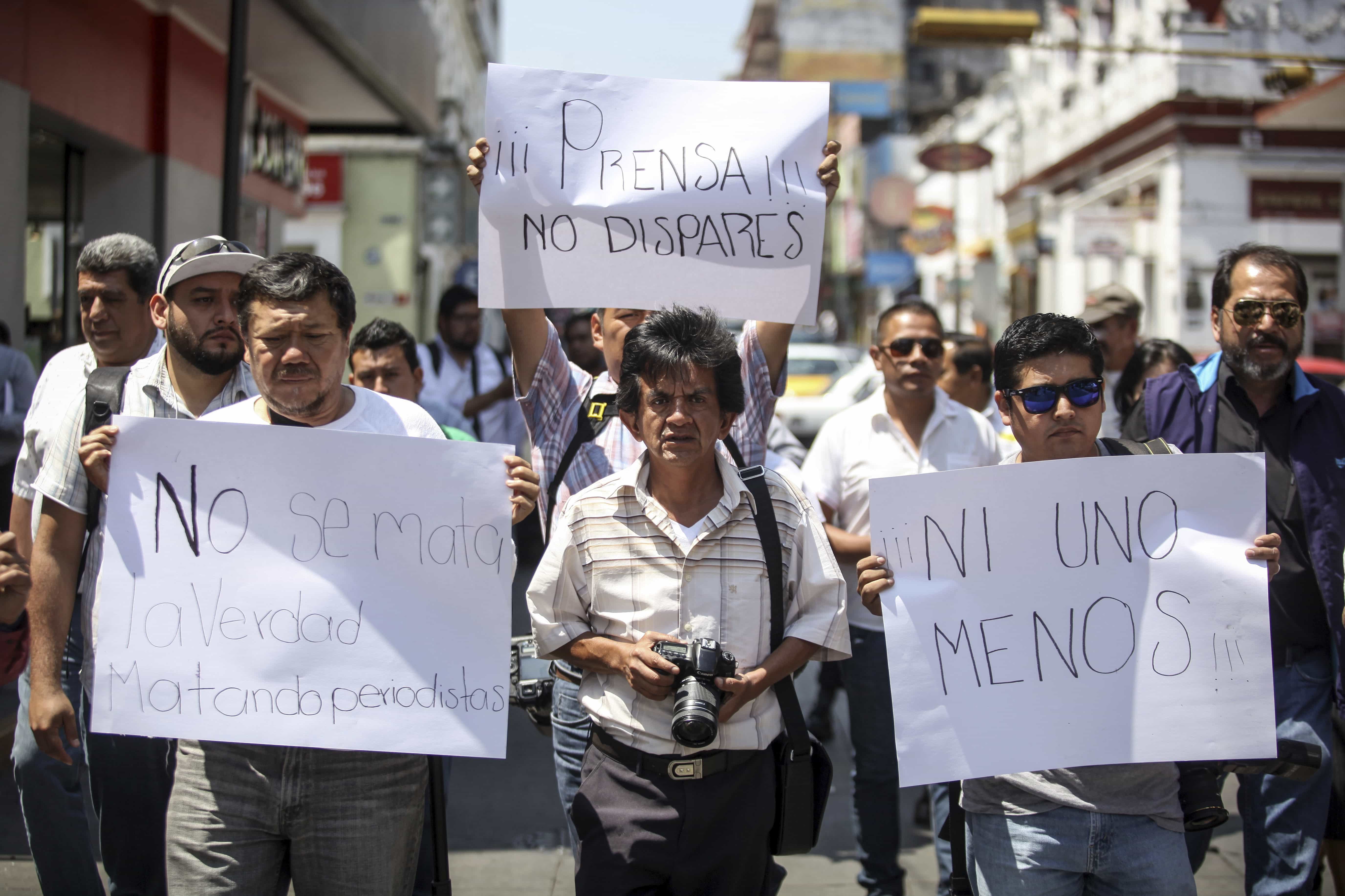 Journalists carry signs reading "Press, don't shoot!," "Not one less," and "Killing journalists doesn't kill the truth," as they protest one day after the killing of their colleague Ricardo Monlui, in Cordoba, Veracruz state, 20 March 2017, AP Photo/Felix Marquez