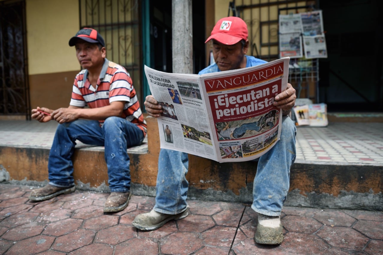 A man reads a newspaper with a headline referring to the murder of journalist Leobardo Vázquez Atzin, in Papantla municipality, Veracruz state, Mexico, 22 March 2018, VICTORIA RAZO/AFP/Getty Images
