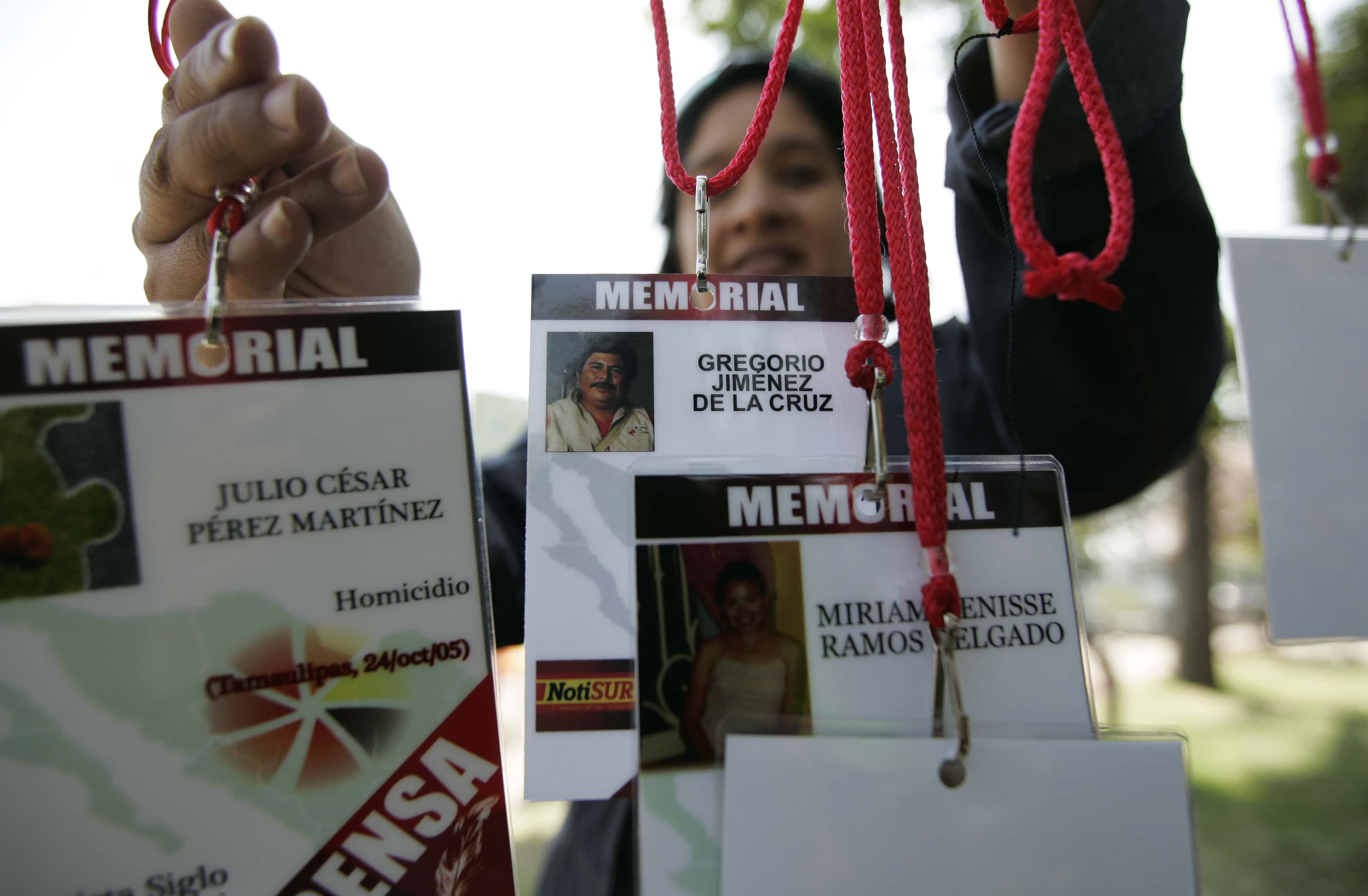 A woman hangs up journalist's accreditations with the names of journalists killed in the last years while covering the news in Mexico, REUTERS/Alejandro Acosta