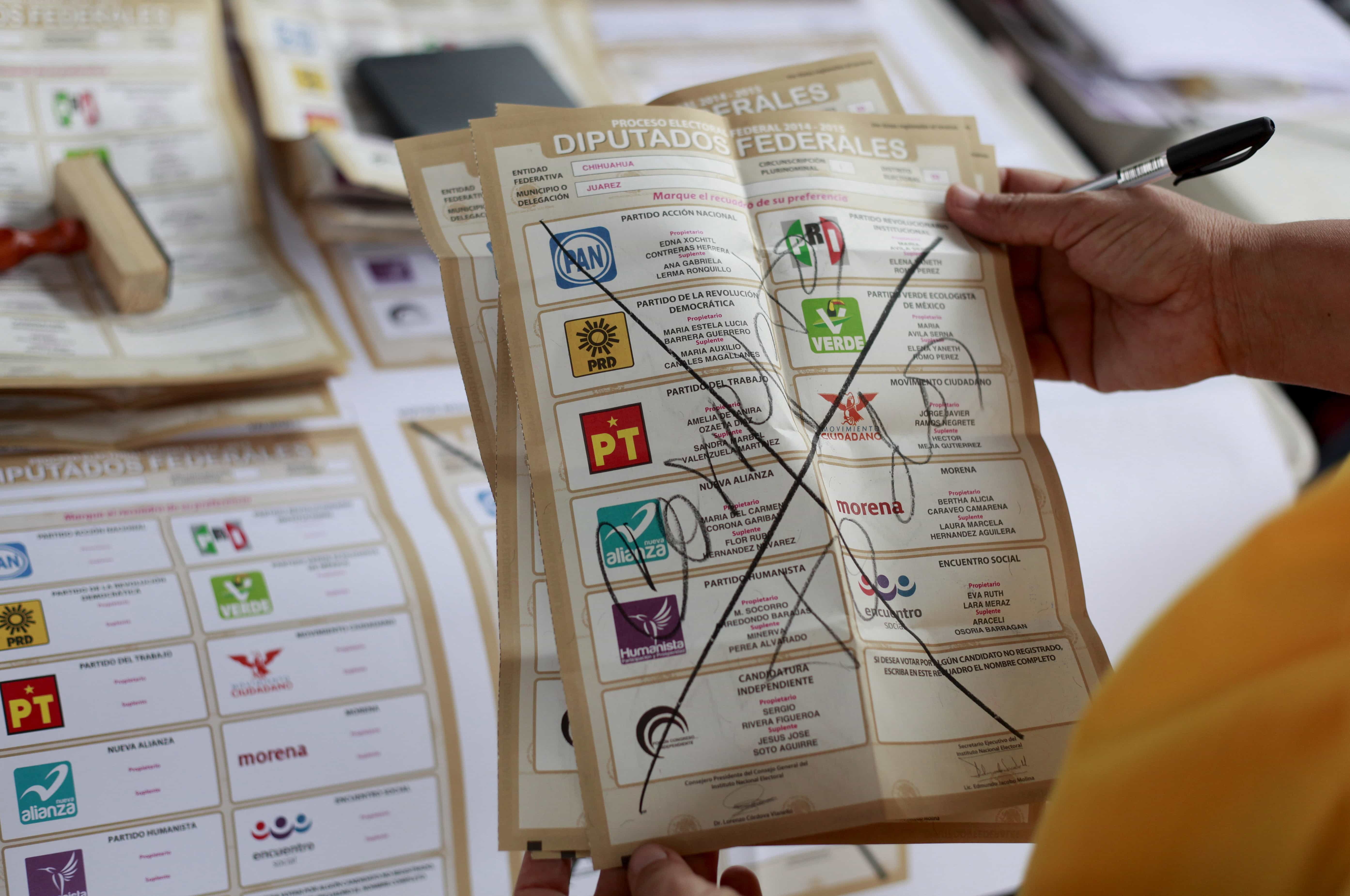 An election official shows a spoilt ballot, with the words 'All corrupt', as votes are counted at a polling station after midterm elections in Ciudad Juarez, Mexico, 7 June 2015, REUTERS/Jose Luis Gonzalez