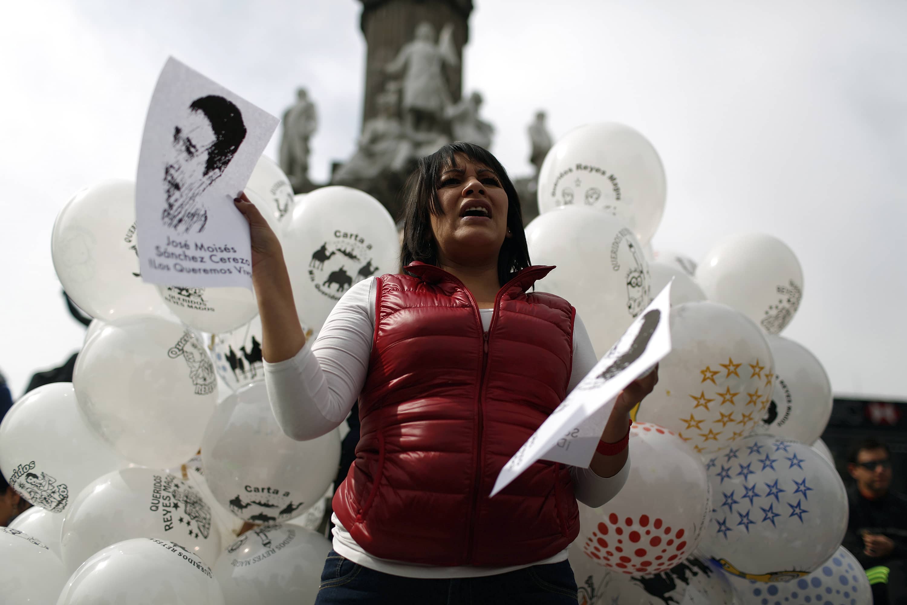 An activist holds a picture of missing journalist Moises Sanchez, during the "Globos por Ayotzinapa" activity at at Angel de la Independencia monument in Mexico City on 4 January 2015, REUTERS/Tomas Bravo