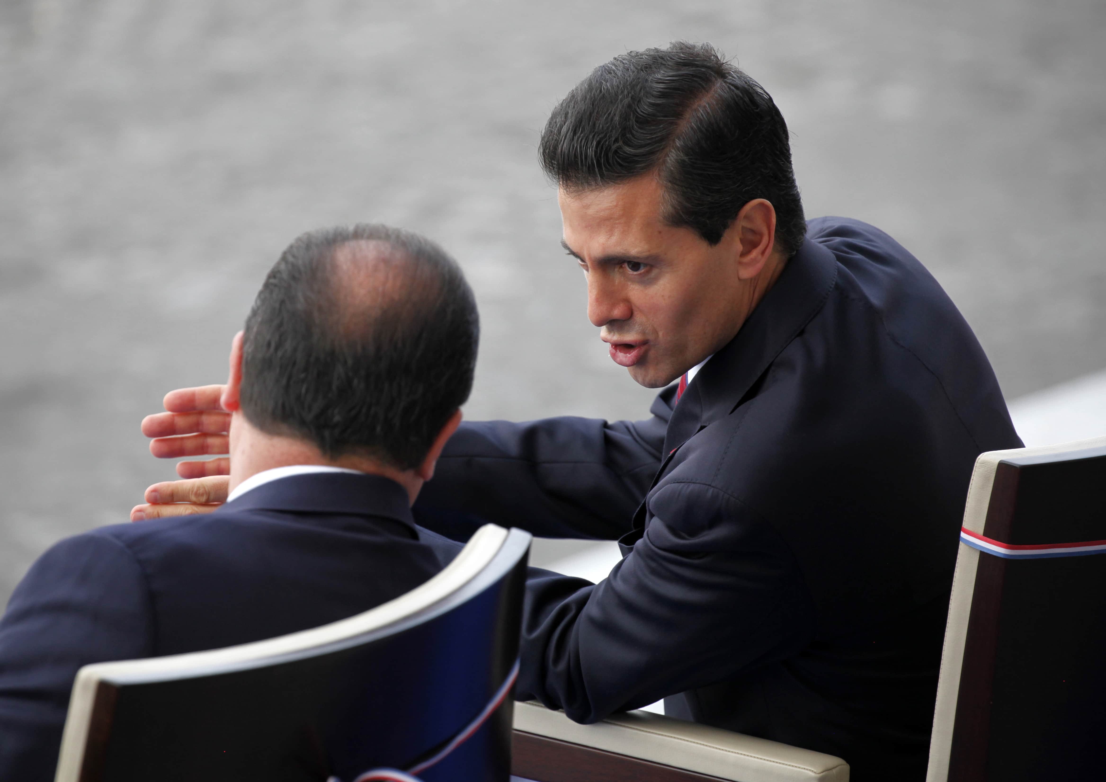 French President Francois Hollande (L) speaks with Mexico's President Enrique Pena Nieto during the traditional Bastille Day military parade in Paris, France, July 14, 2015, REUTERS/Mal Langsdon