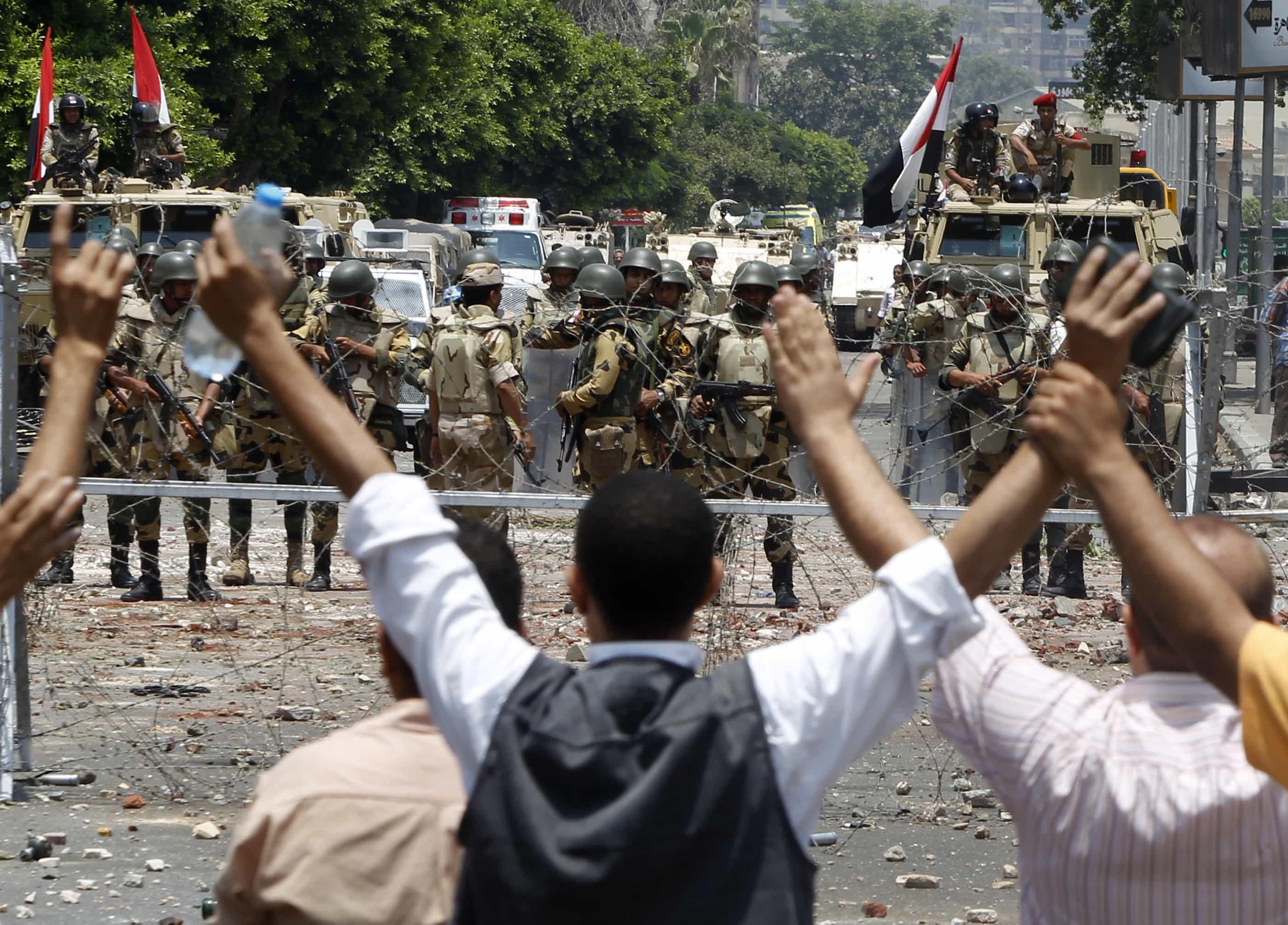 Supporters of the deposed Egyptian president shout slogans in front of army soldiers at Republican Guard headquarters in Cairo on 8 July 2013, REUTERS/Amr Abdallah Dalsh