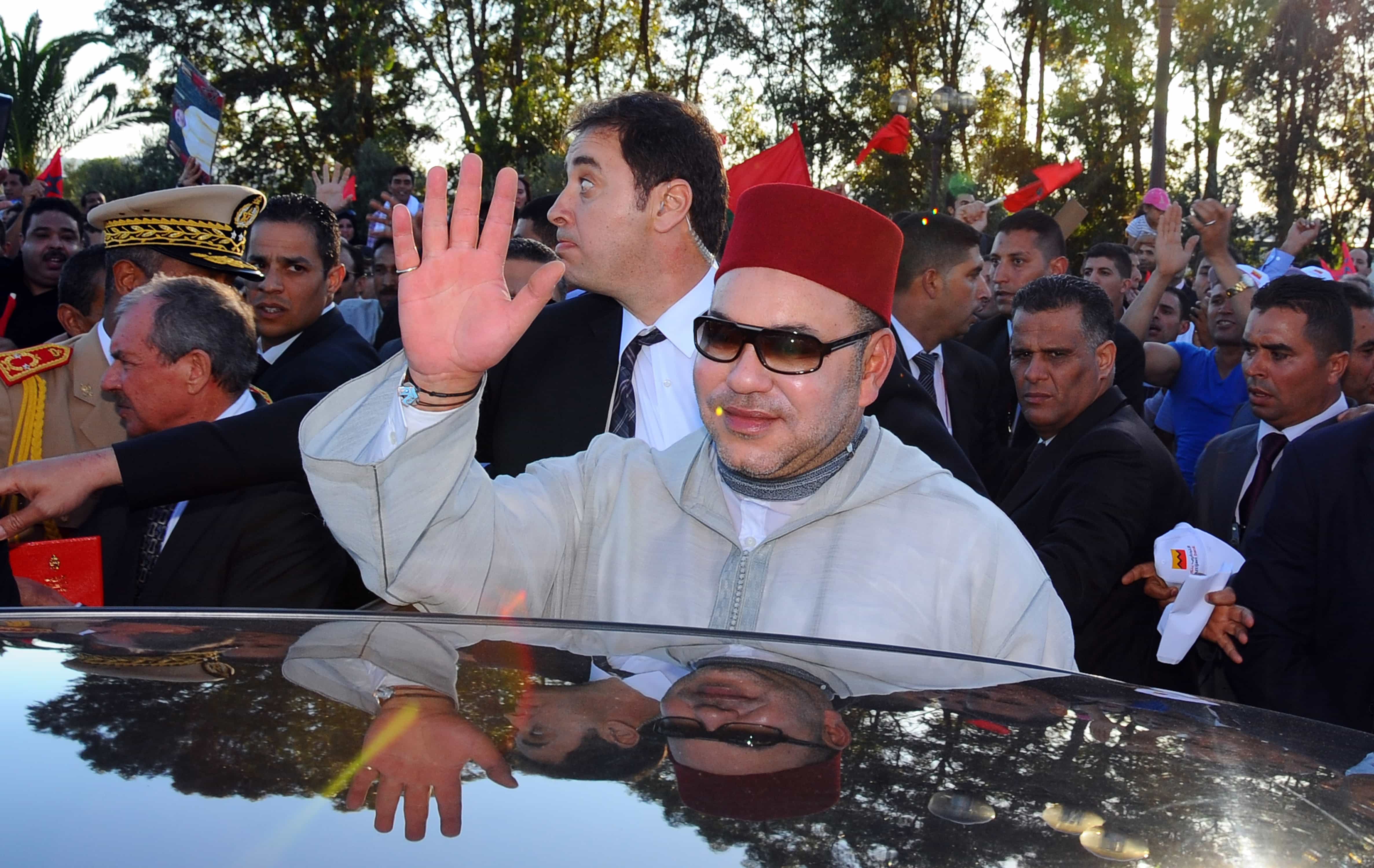 Morocco's King Mohammed VI waves, upon his arrival at Tunis airport, Friday May 30, 2014, AP Photo/Hassene Dridi