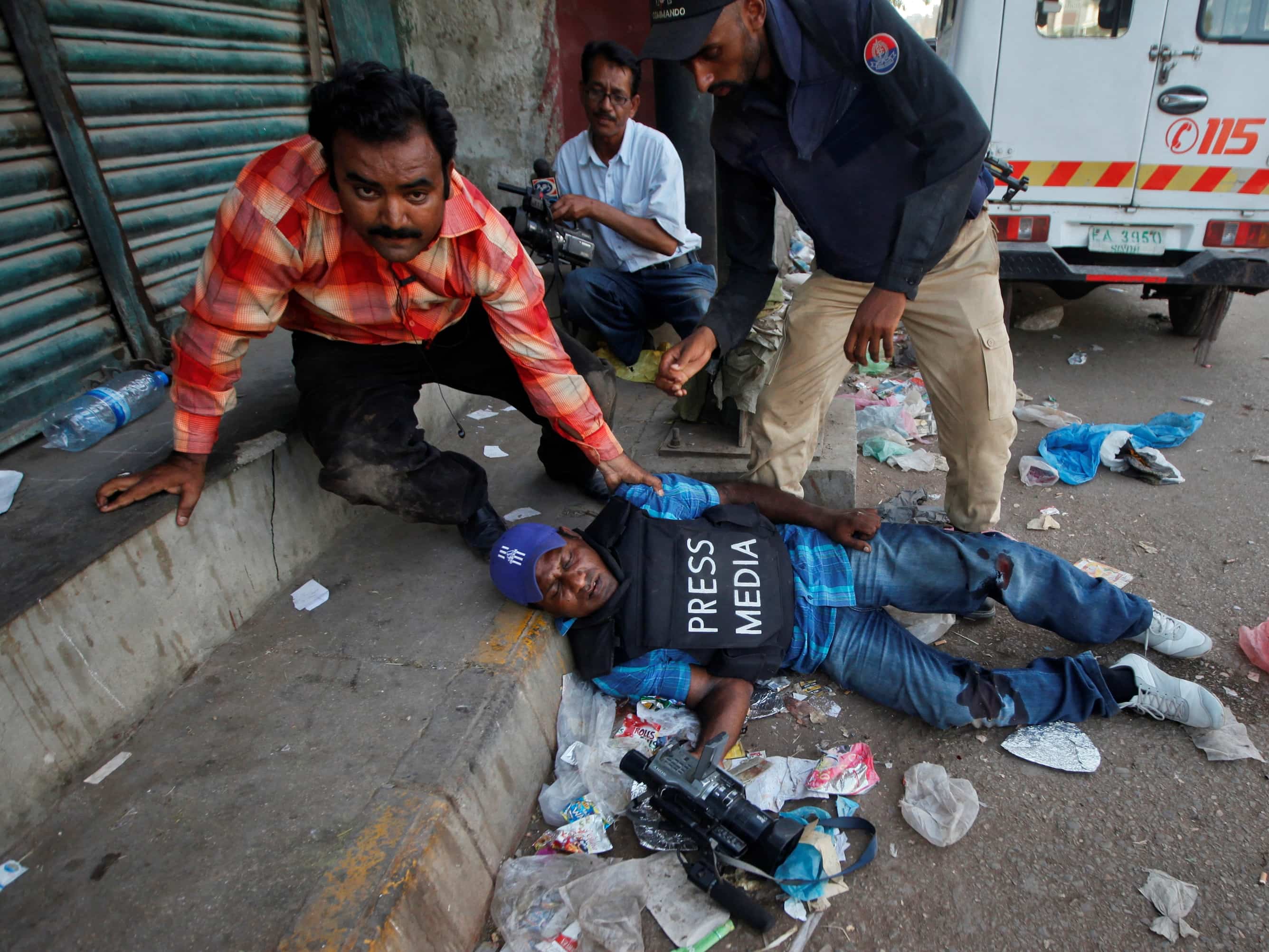 An injured Pakistani cameraman is attended to during a firefight in Karachi, April 2012. Photo features in CPJ's "The Year in Photographs" gallery, REUTERS/Athar Hussain