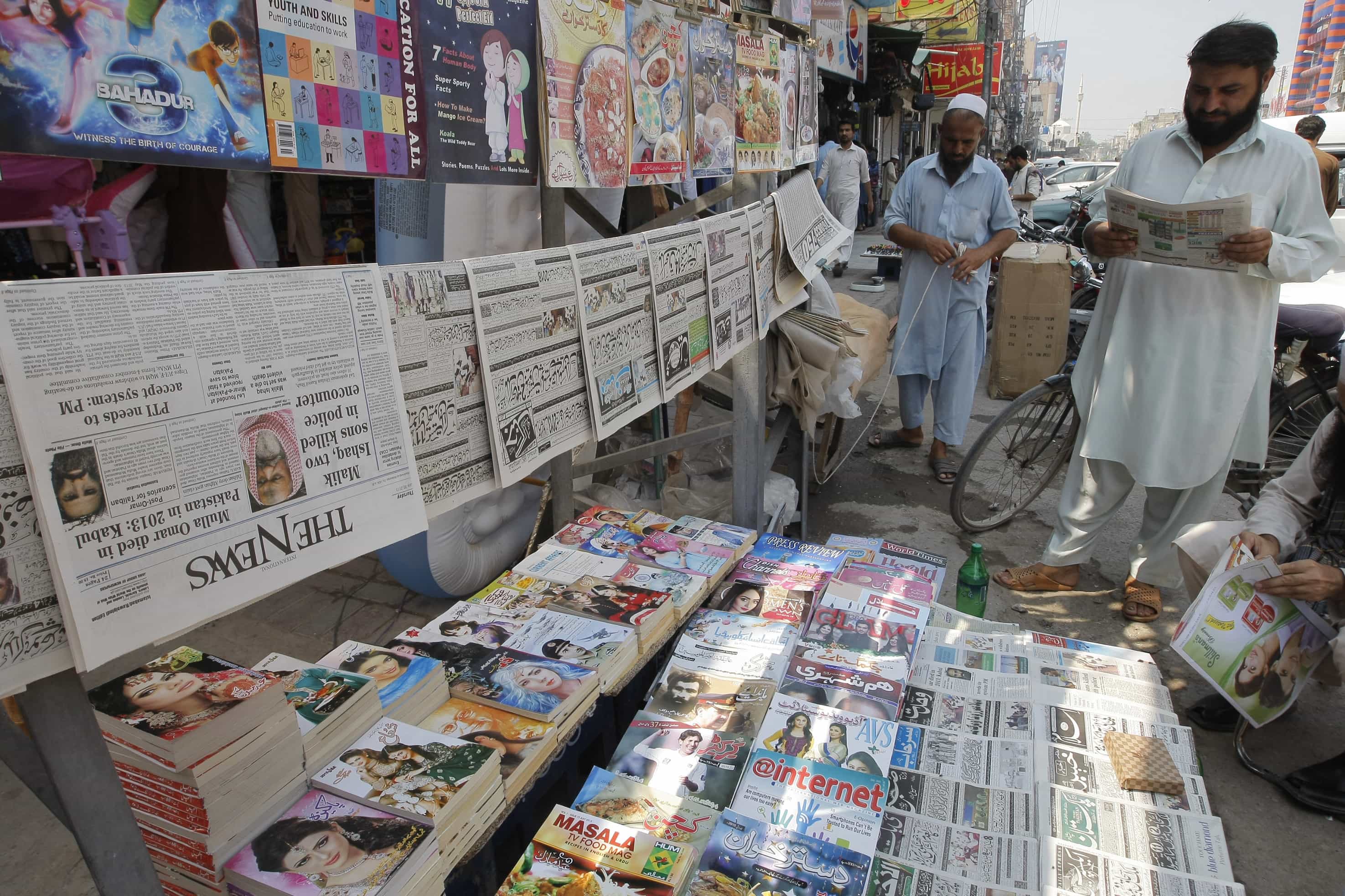 A man reads a newspaper at a news stand in Peshawar, 30 July 2015, AP Photo/Mohammad Sajjad