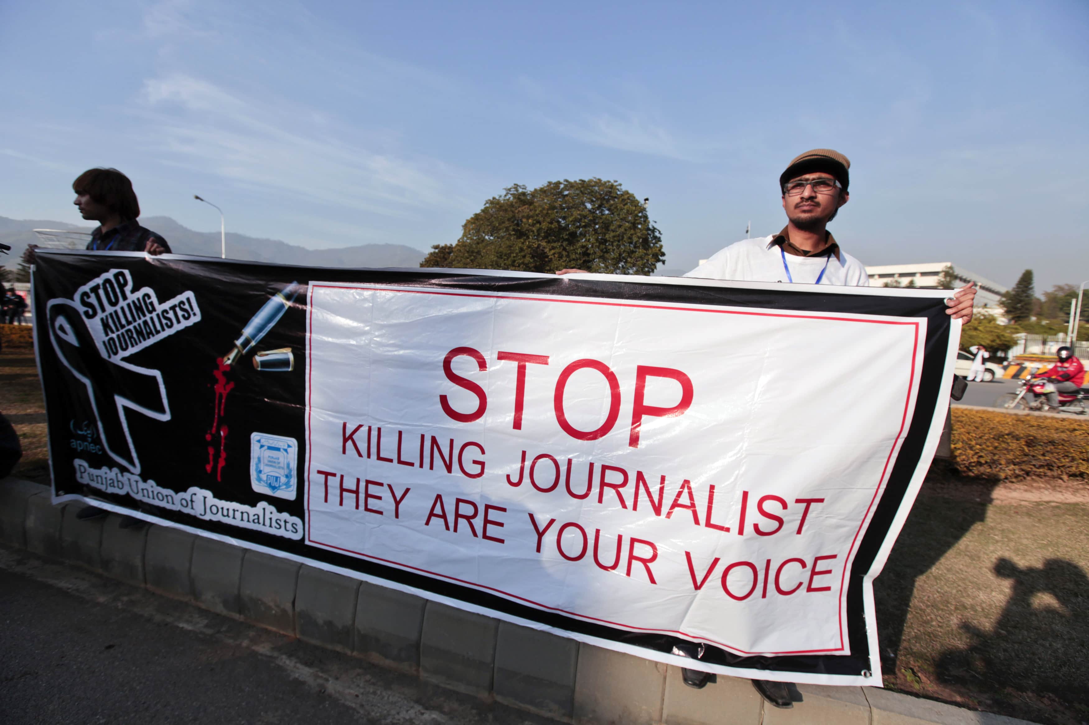 Journalists hold a banner while taking part in a demonstration in front of the Parliament building in Islamabad, on 28 January 2013, REUTERS/Faisal Mahmood