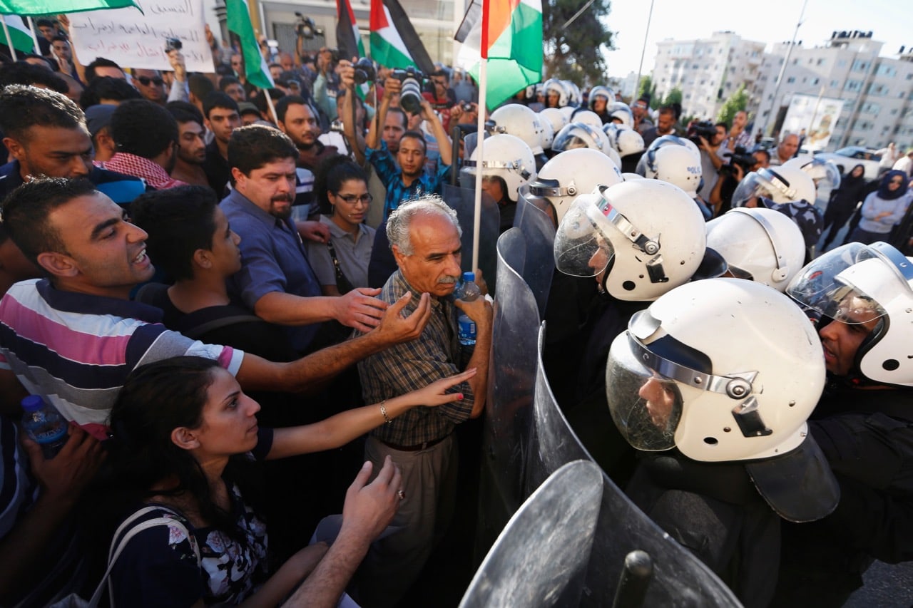 Protesters argue with Palestinian riot police during a protest against security coordination between the Palestinian authority and Israel, in the West Bank city of Ramallah, 23 June 2014, REUTERS/Mohamad Torokman