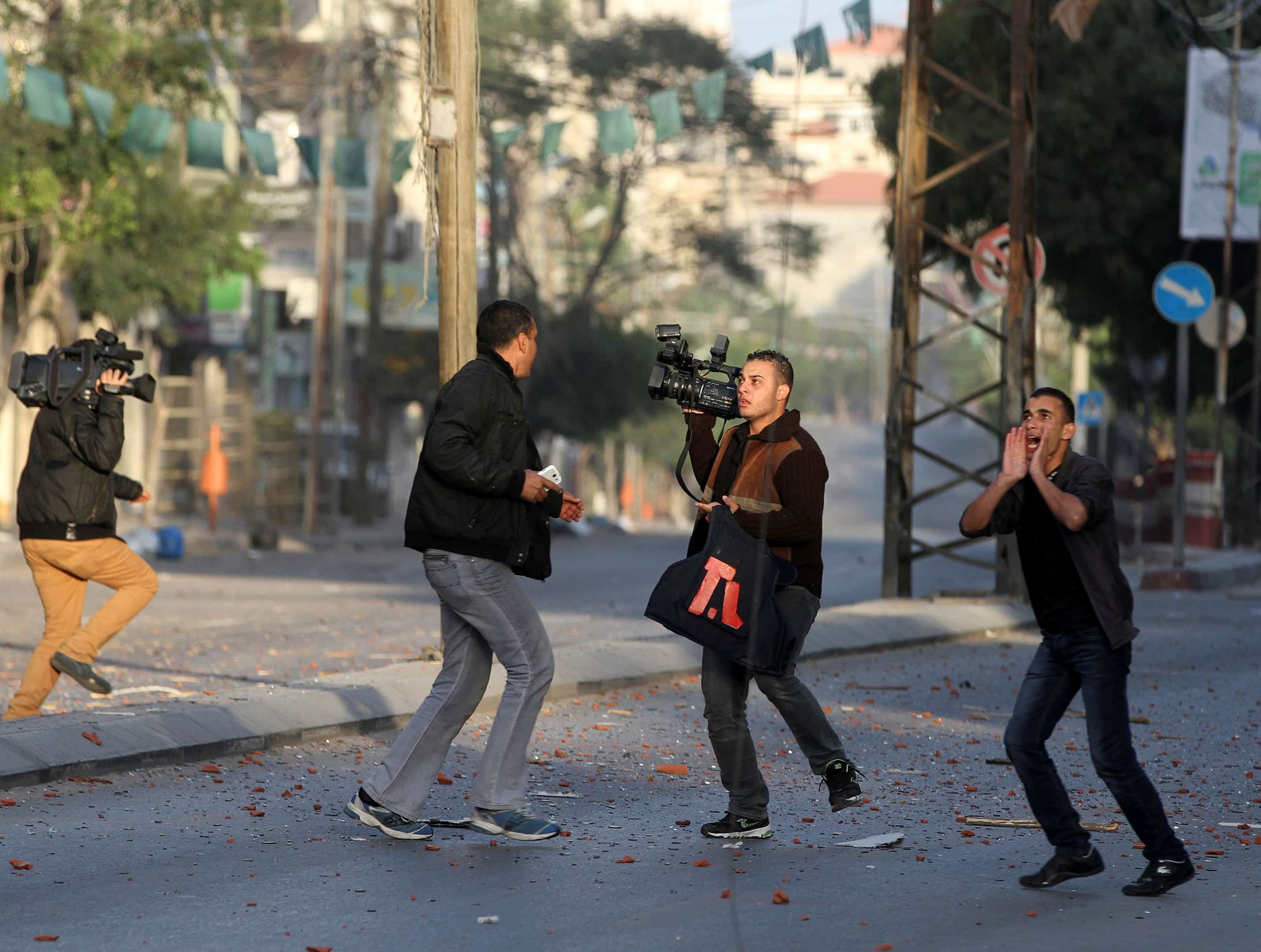 Palestinian journalists react after an Israeli air strike on the office of Hamas television channel Al-Aqsa in a building that also houses other media in Gaza on 18 November 2012, REUTERS/Majdi Fathi