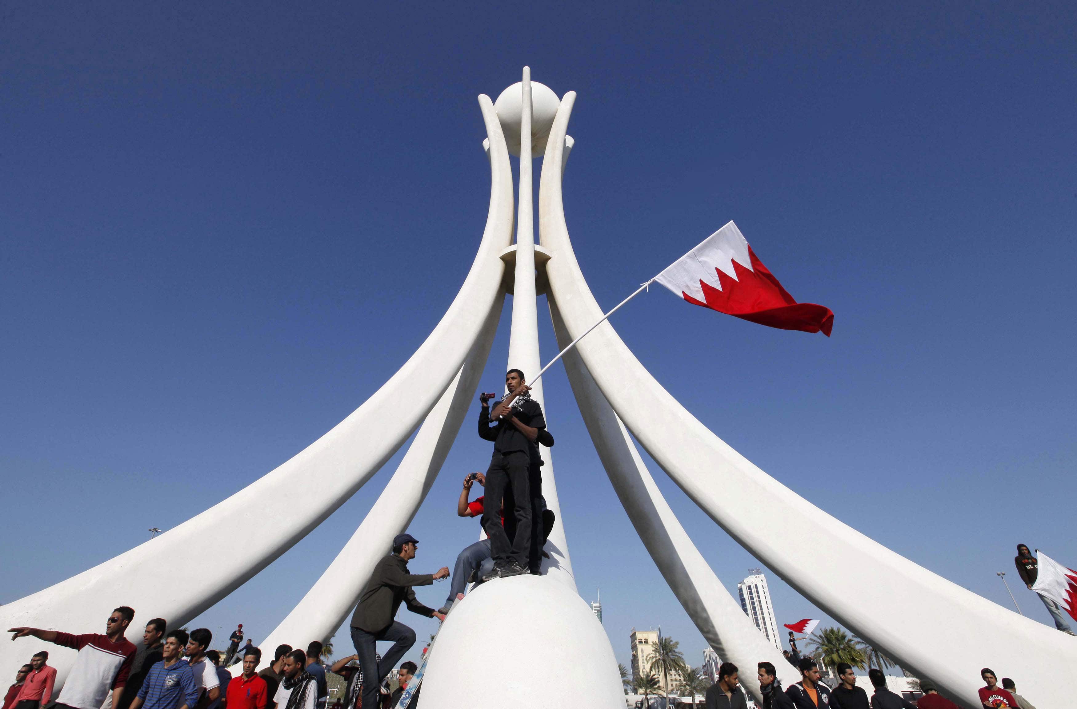 Protesters stand at the base of the Pearl Roundabout in the Bahraini capital of Manama, February 15, 2011, REUTERS/Hamad I Mohammed