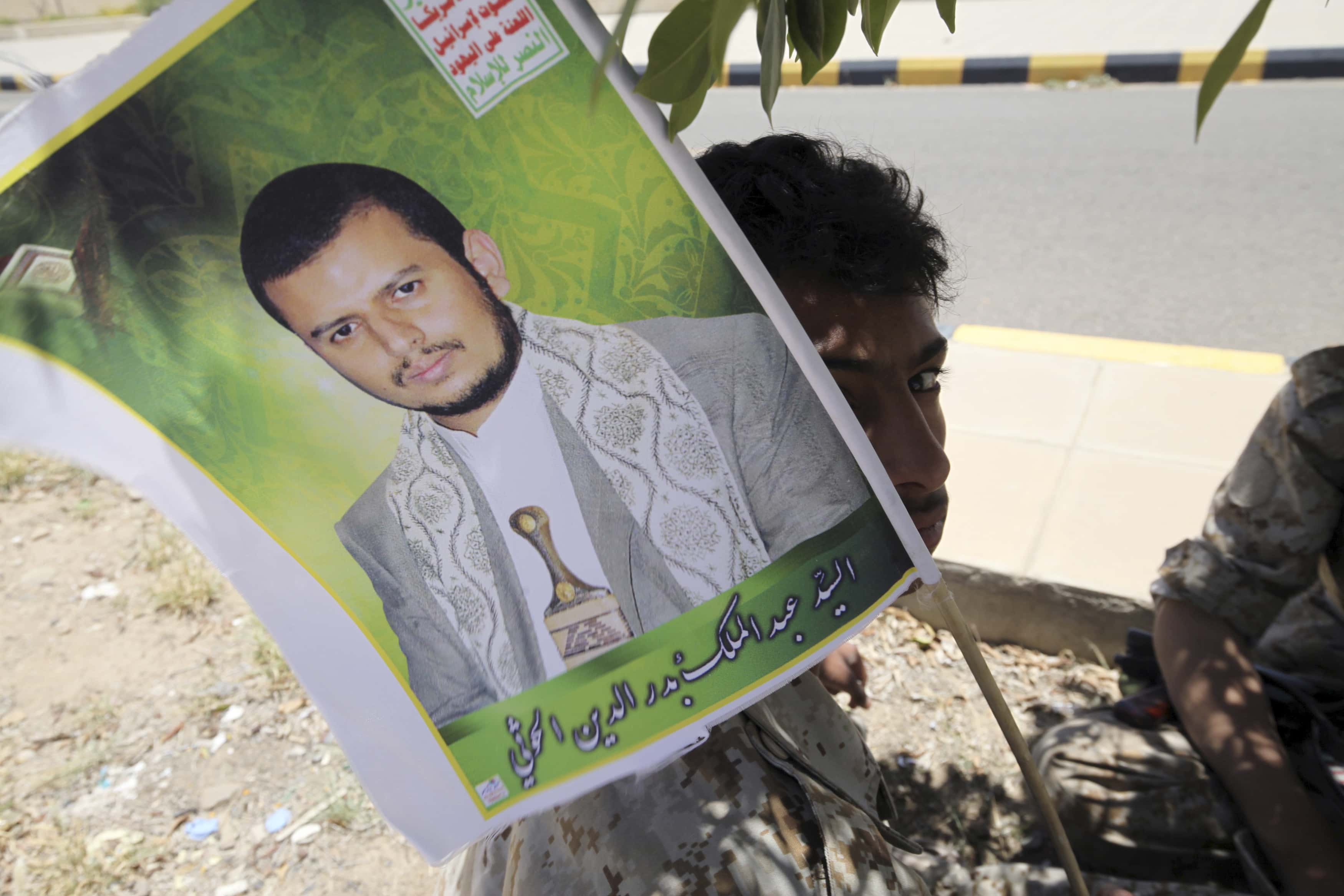 A youth dressed in military uniform holds up a poster of the Houthi movement's leader Abdel-Malek Badruddin al-Houthi , REUTERS/Mohamed al-Sayaghi