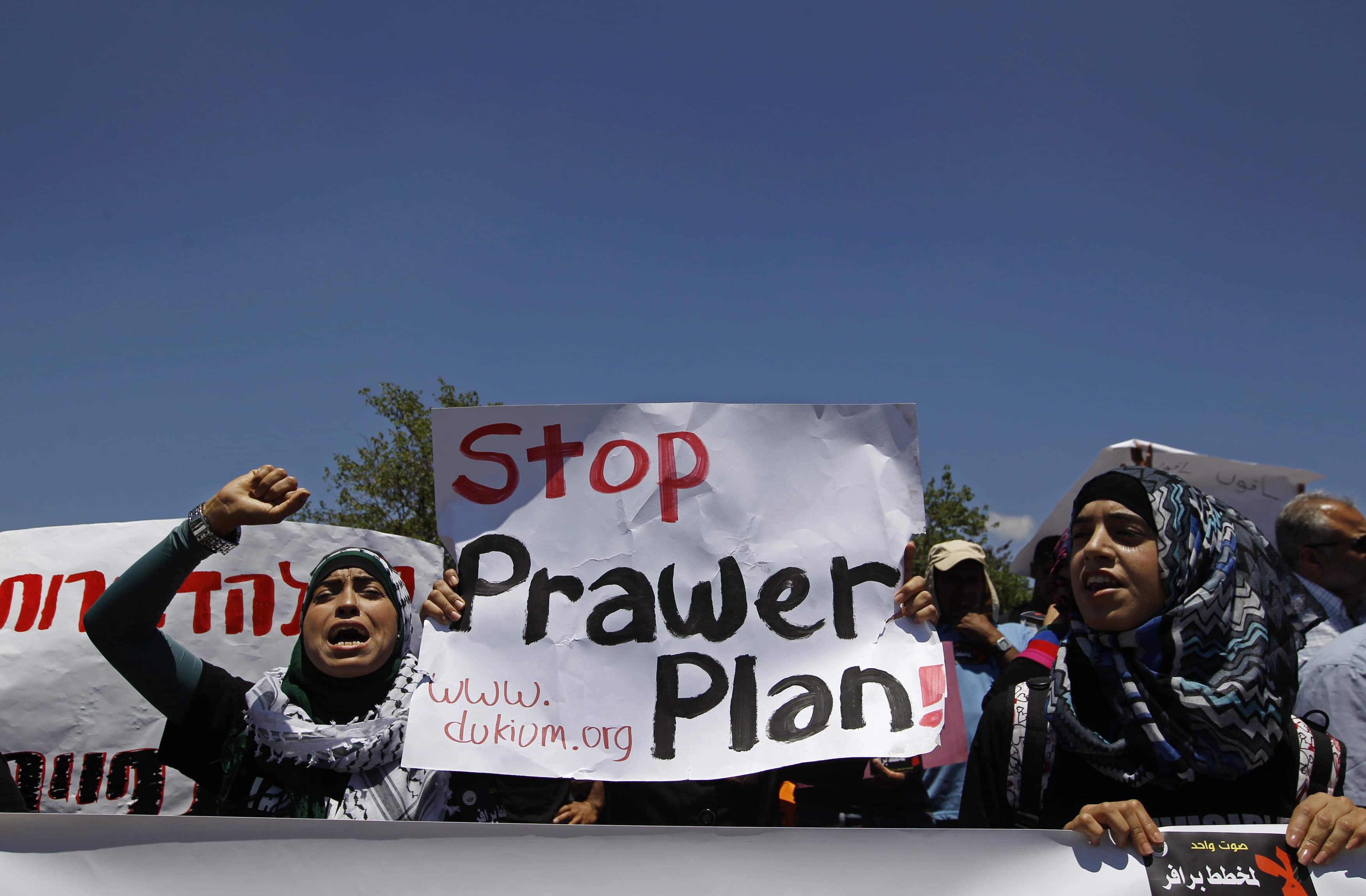 Bedouins hold signs as they take part in a protest against the Prawer Plan in the Negev desert, REUTERS/Ammar Awad