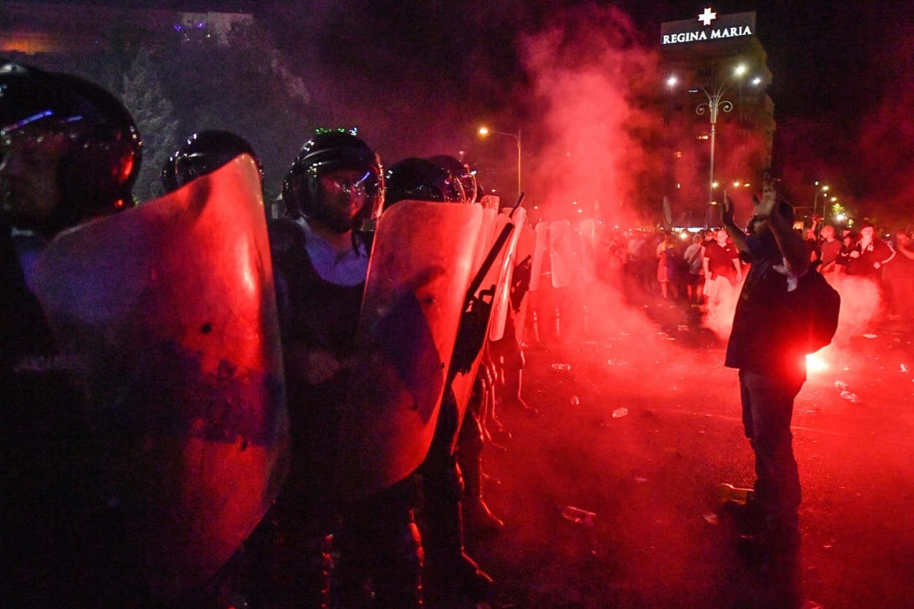 A man stands in front of anti-riot police during a demonstration in front of the Romanian Government headquarters, in Bucharest, 10 August 2018, DANIEL MIHAILESCU/AFP/Getty Images