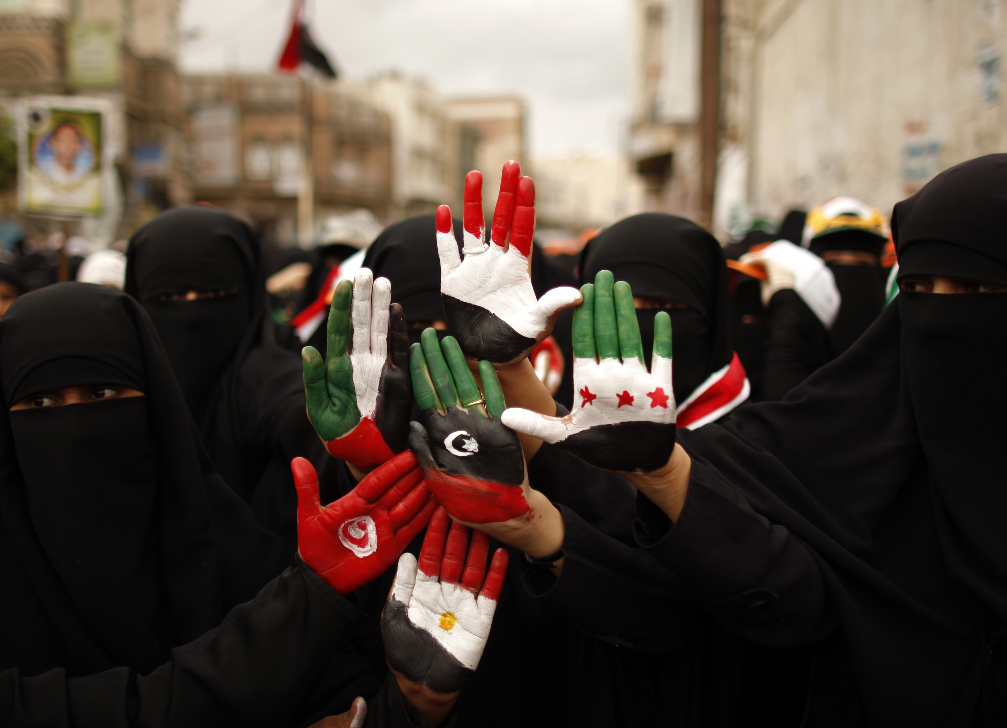 Female anti-government protesters display their hands, painted with the colours of the flags of Yemen, Egypt, Tunisia and Syria, during a demonstration in Sanaa, REUTERS/Khaled Abdullah