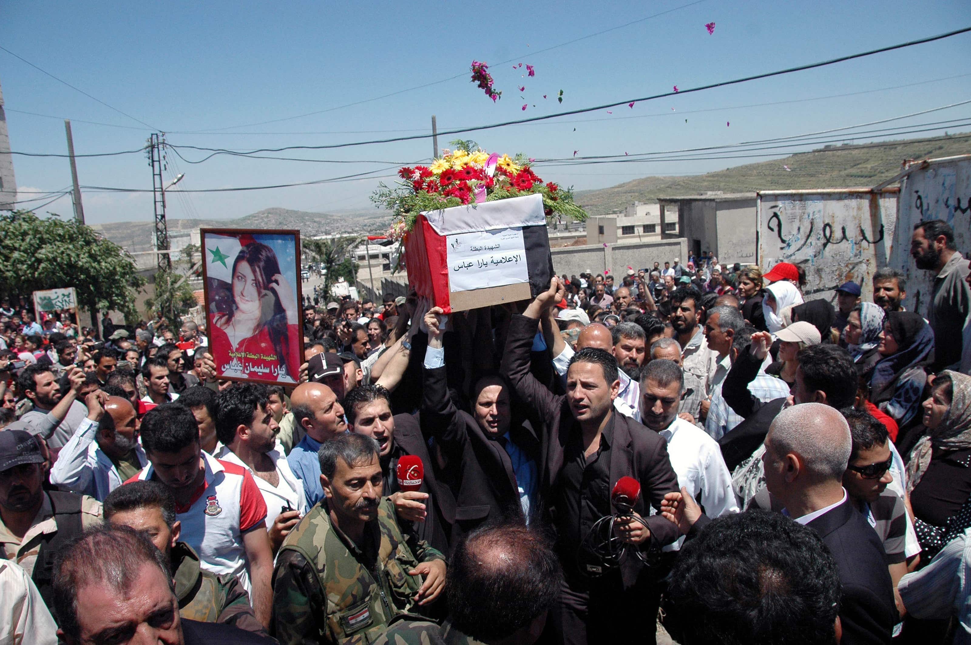 Mourners carry the coffin of Yara Abbas, a reporter for the al-Ikhbariya news channel, during her funeral in Nisyaf village in the countryside of Hama city on 28 May 2013, SANA/Handout via Reuters